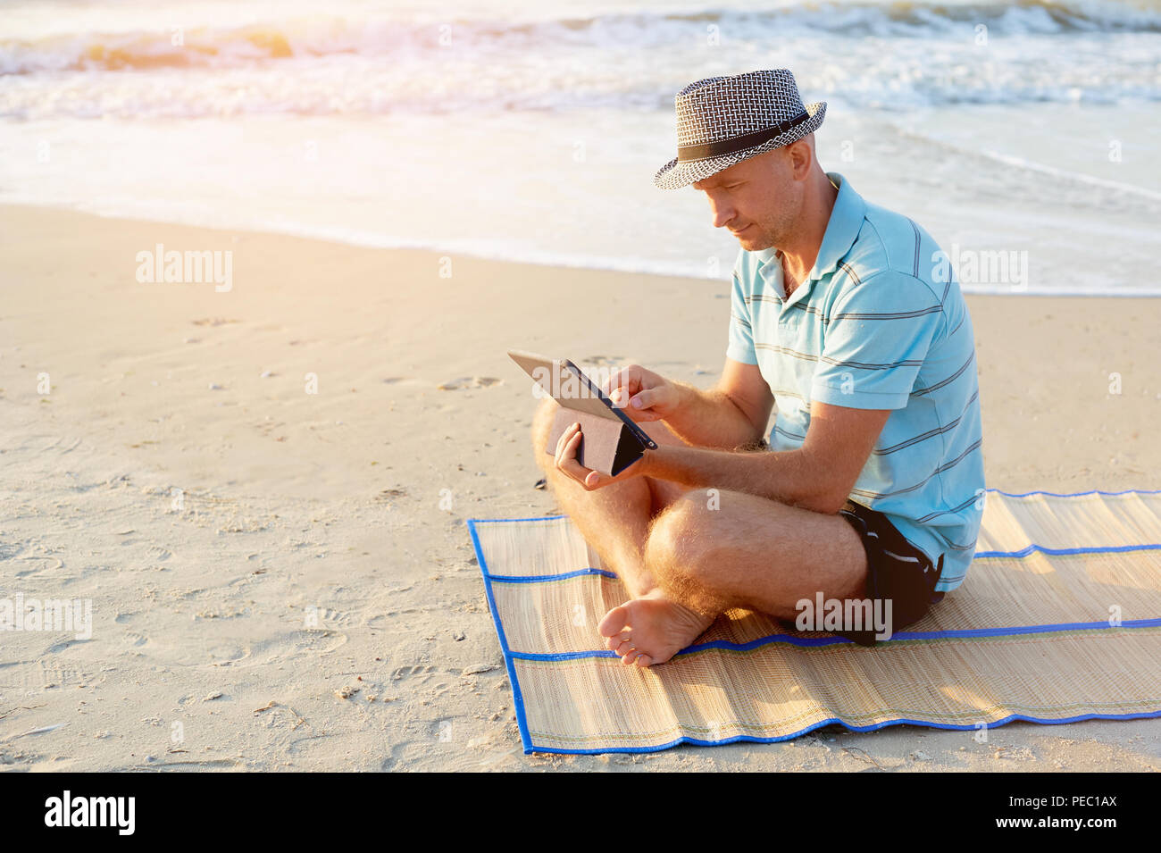 Älterer Mann bei der Arbeit auf seinem Laptop am Strand bei Sonnenuntergang, Freiberufler Konzept in Reisen Stockfoto Älterer Mann bei der Arbeit auf seinem Laptop am Strand bei Sonnenuntergang, Freiberufler Konzept in Reisen Stockfoto