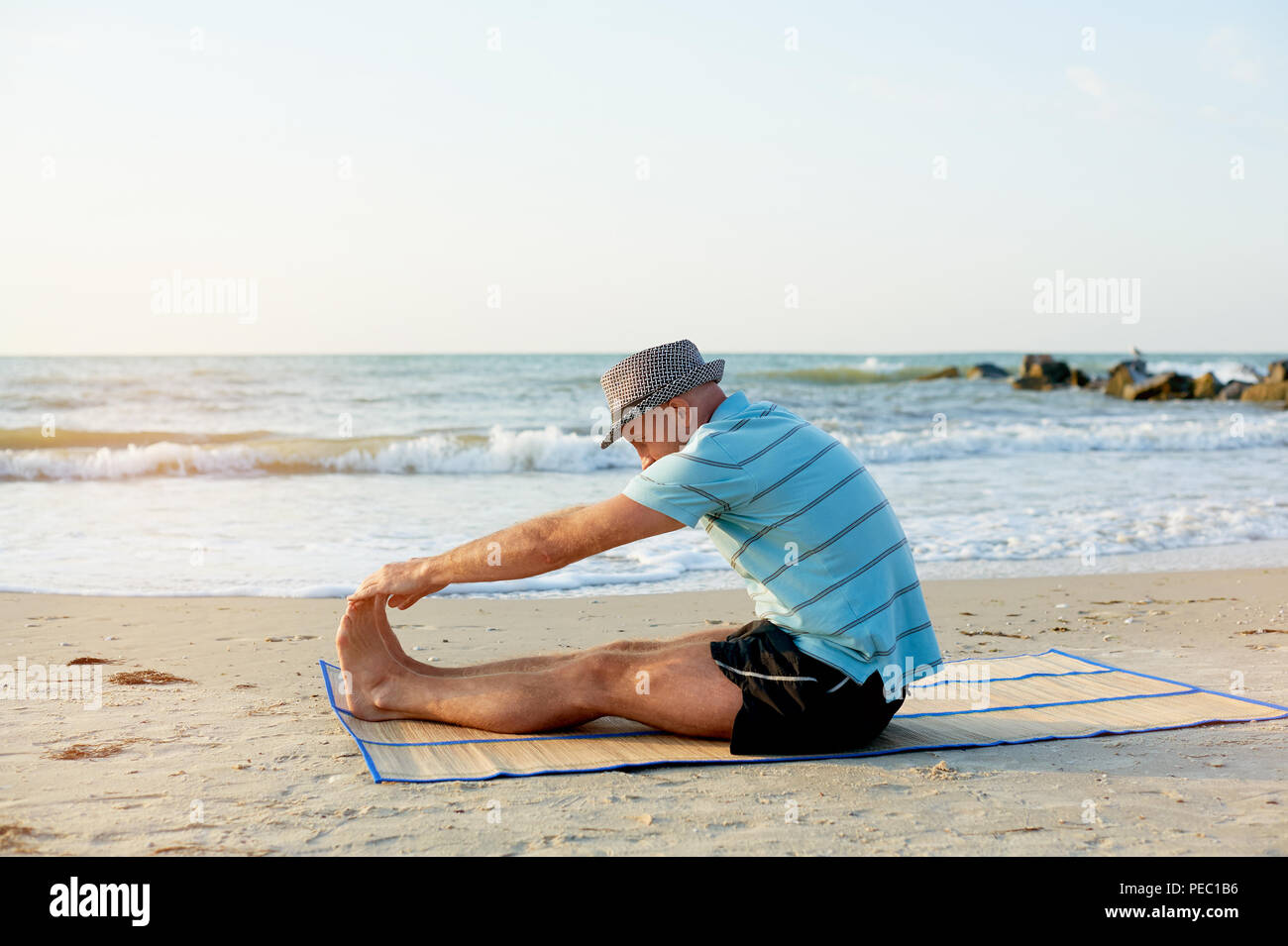 Passen Mann außerhalb morgendliches Warm-up Stretching, Blick auf Meer. Fitness und Sport Konzept Stockfoto