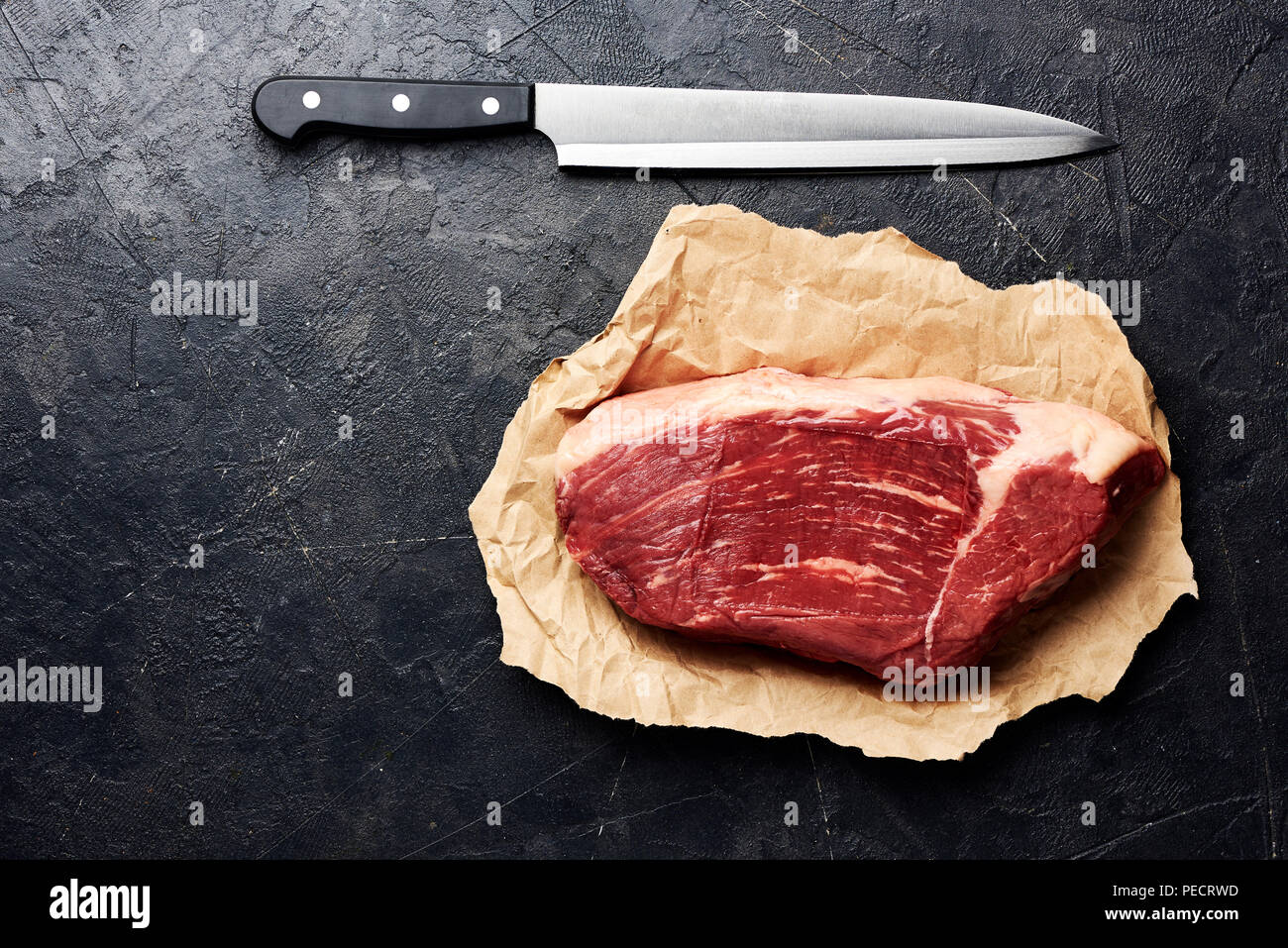 Rohe frische marmoriertes Fleisch Black Angus Steak und Fleisch Messer. Fleisch auf schwarzen Hintergrund mit kopieren. Ansicht von oben. Stockfoto