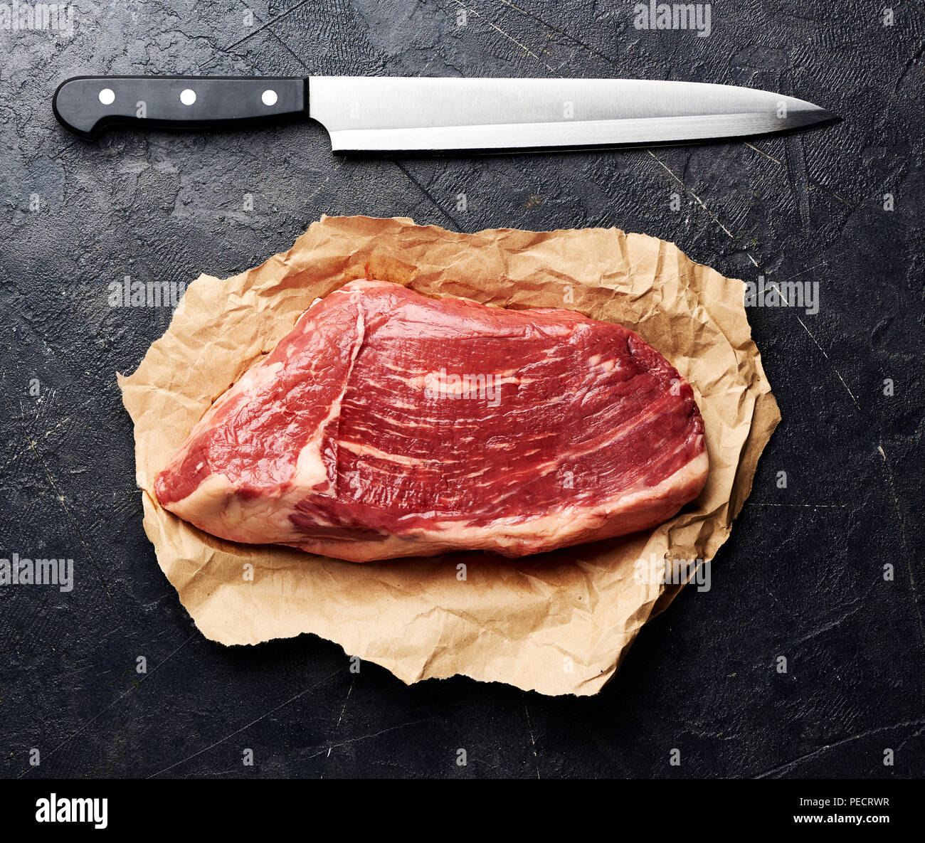 Rohe frische marmoriertes Fleisch Black Angus Steak und Fleisch Messer. Fleisch auf schwarzem Hintergrund. Ansicht von oben. Stockfoto