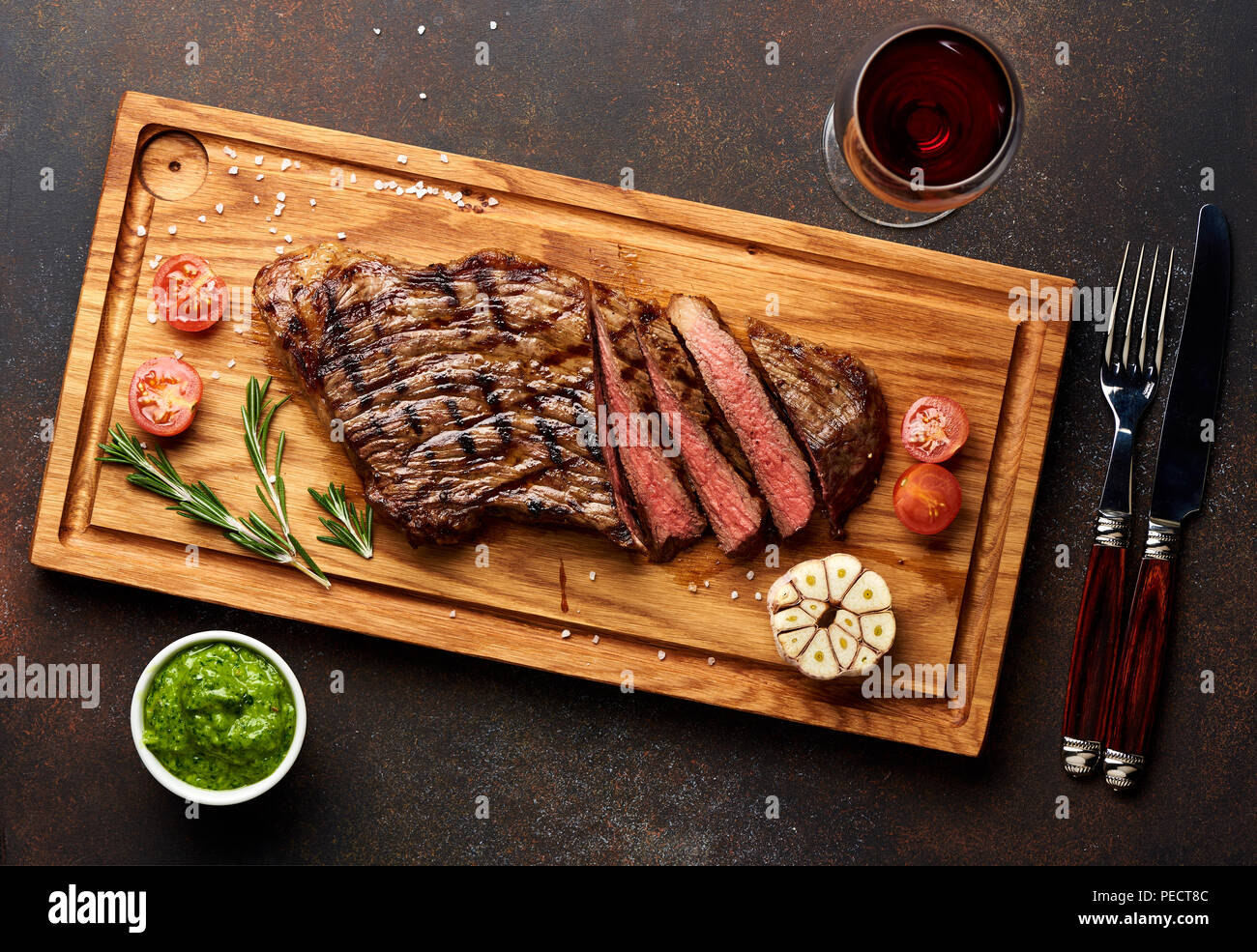 Black Angus Steak vom Grill und ein Glas Rotwein mit chimichurri Sauce für Fleisch Schneidebrett. Stockfoto