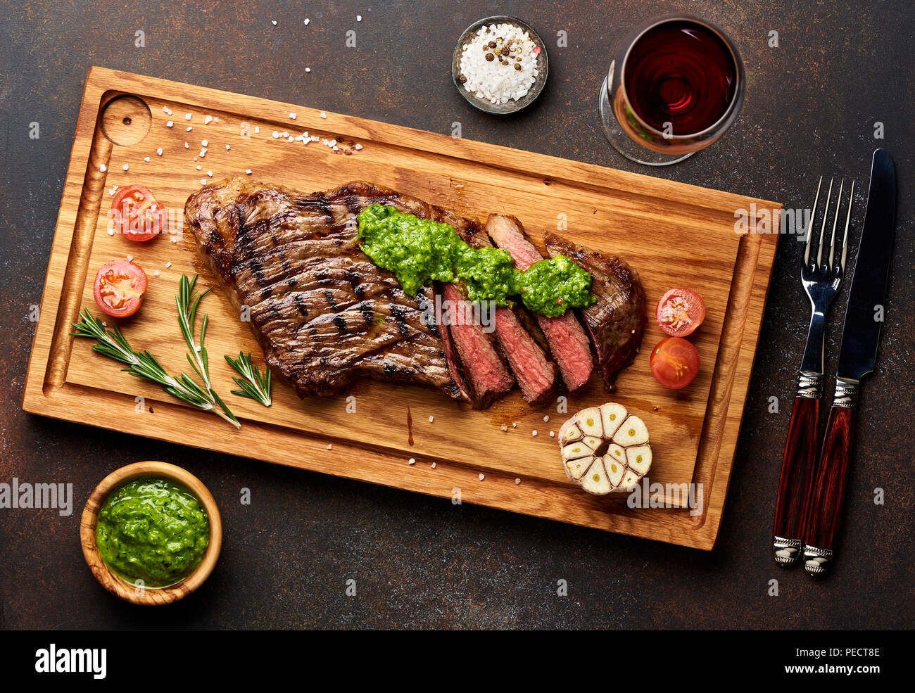 Black Angus Steak vom Grill und ein Glas Rotwein mit chimichurri Sauce für Fleisch Schneidebrett. Stockfoto