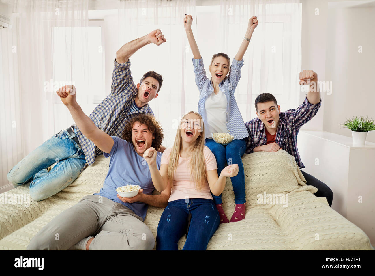 Eine Gruppe von Freunden von Fans auf eine Sport-TV auf einem Sof sitzen Stockfoto