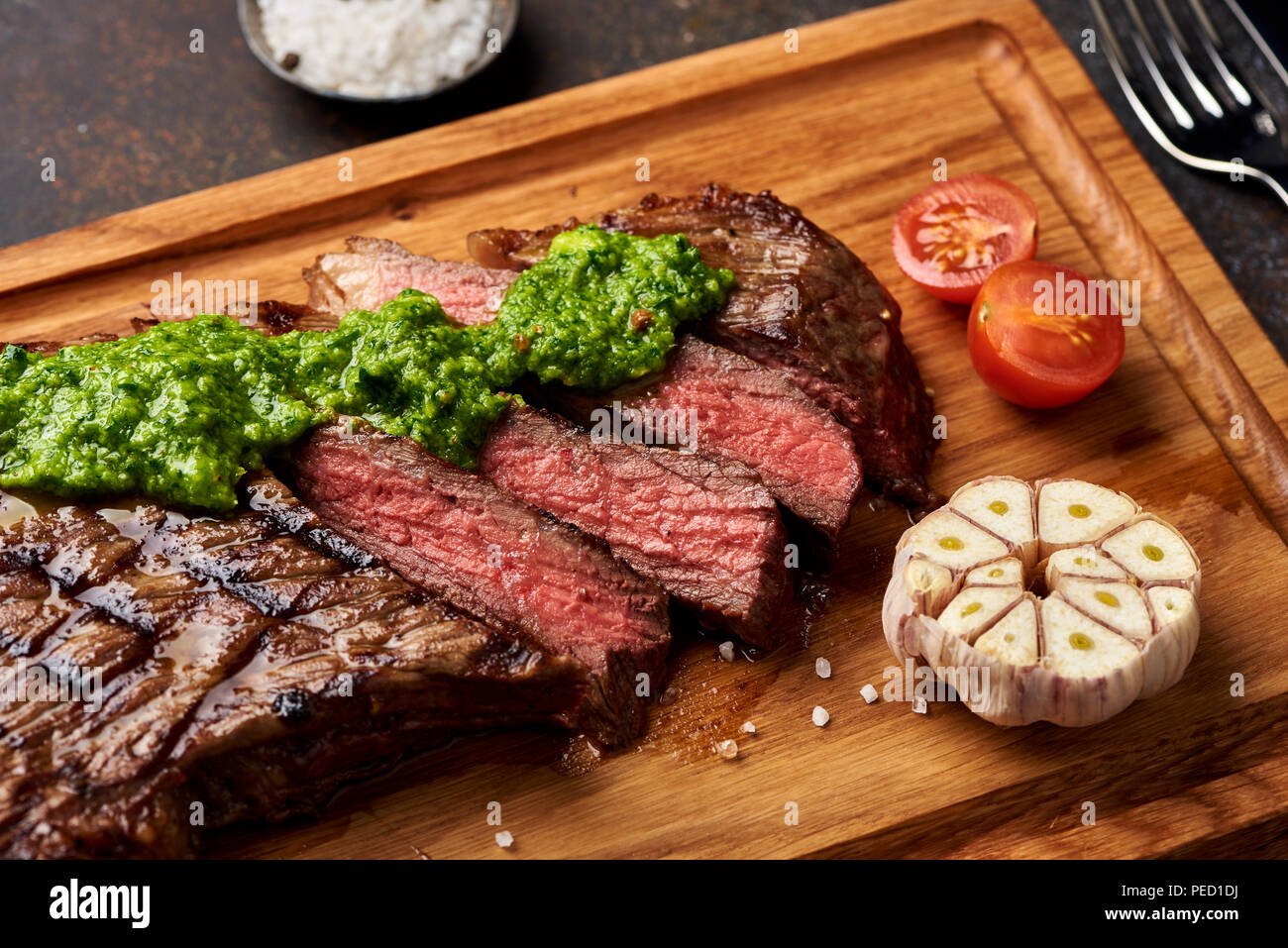 Black Angus Steak vom Grill mit Tomaten, Knoblauch mit chimichurri Sauce für Fleisch Schneidebrett. Stockfoto