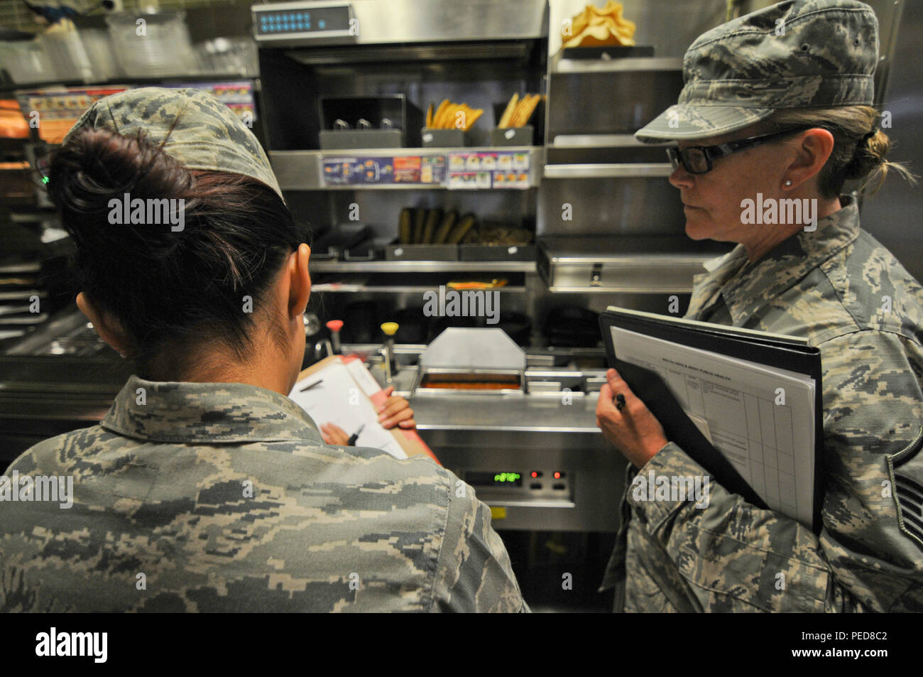 Us Air Force Senior Airman Alejandra Morales, Links, und Master Sgt. Patricia Hughes, öffentliche Gesundheit Techniker, Notizen, die während einer Inspektion in einem der Restaurants auf der Spangdahlem Air Base, Germany, Aug 4. Hughes, ein Mitglied der 177th Medical Group die New Jersey Air National Guard, wird auf einer zweiwöchigen Training Mission arbeiten mit Morales und der 52 medizinischen Gruppe mission Bereitschaft sicherzustellen, und in der Ausbildung Möglichkeiten nicht ohne Weiteres an ihrem Haus Einheit zur Verfügung. (U.S. Air National Guard Foto von älteren Flieger Shane S. Karp/Freigegeben) Stockfoto