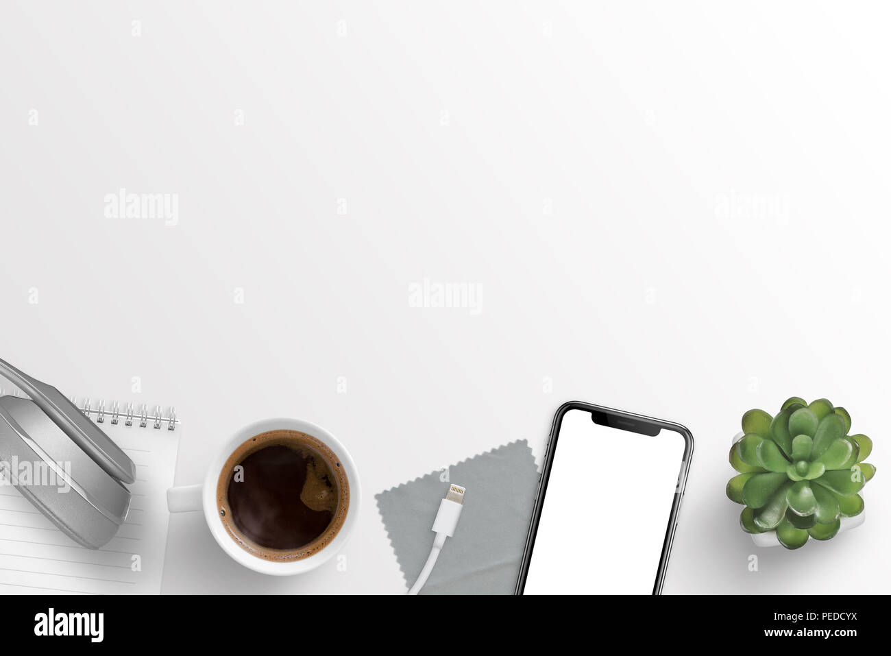 Büro Schreibtisch Zusammensetzung mit Kopfhörern, Notepad, Tasse Kaffee, Ladegerät, Tuch, smart phone und Anlage. Freier Platz für Text. Stockfoto