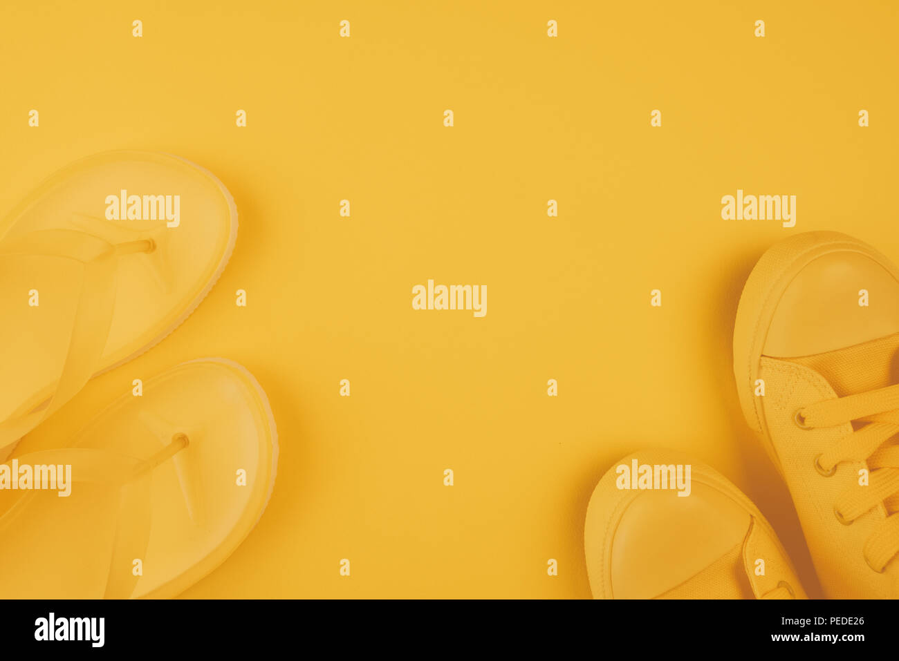 Sommer Schuhe, gelbe Turnschuhe und Flip Flops auf gleiche Farbe Hintergrund mit Kopie Raum Stockfoto