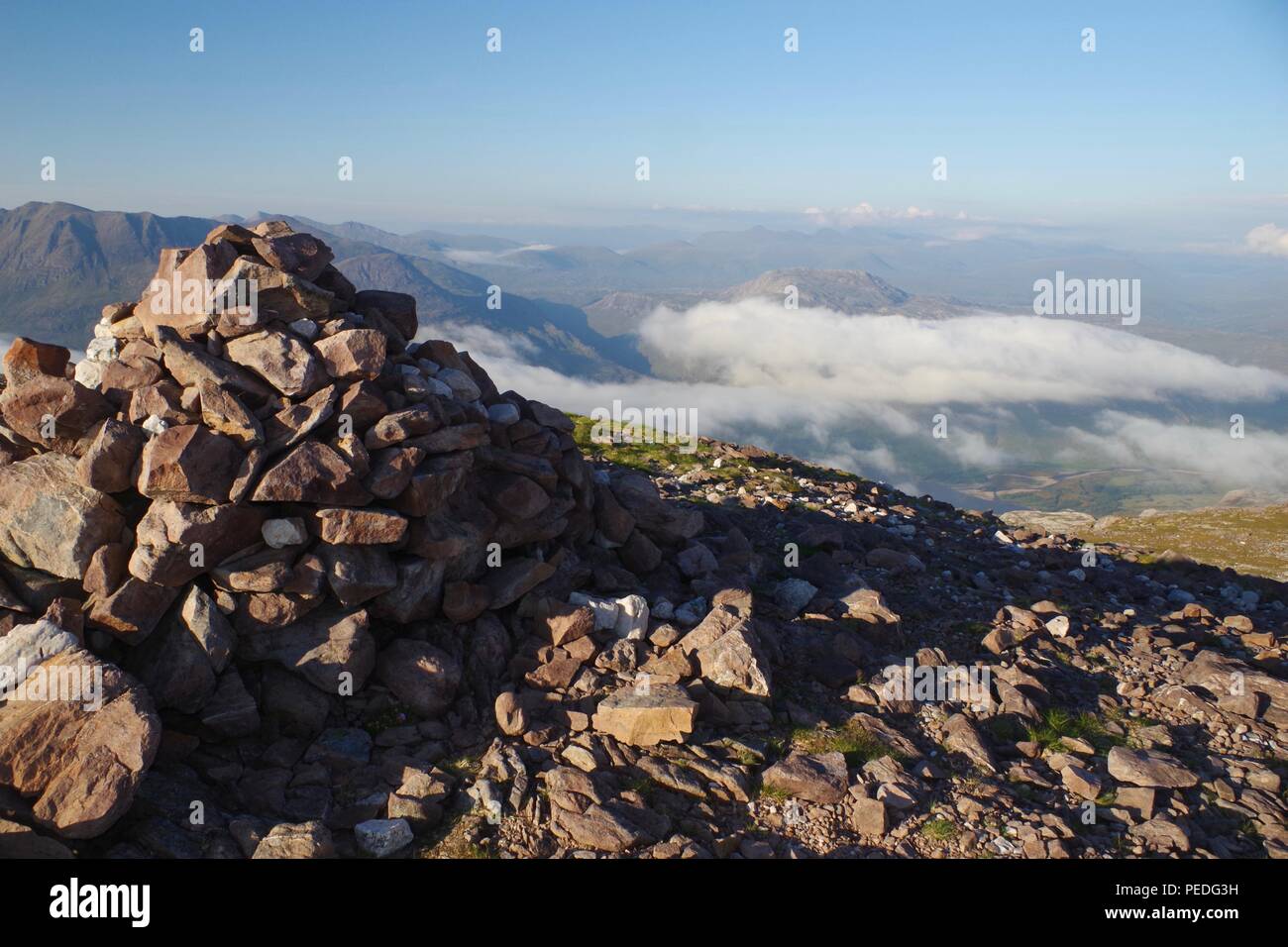 Berg Cairn auf dem Gipfel des Meall aGhiubhais oben eine leichte Wolke Inversion. Beinn Eighe, Torridon, Schottland, Großbritannien. Stockfoto