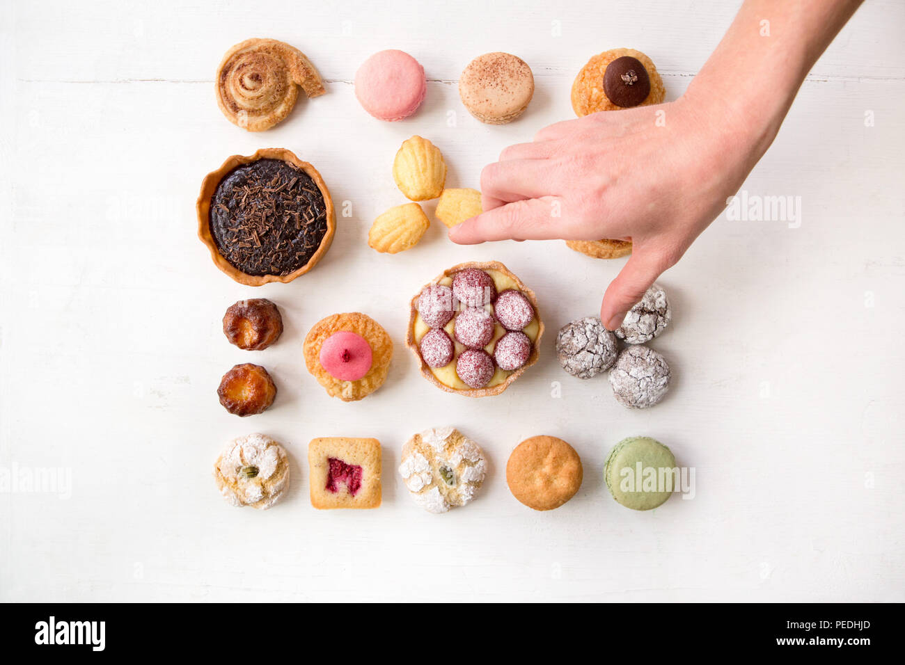 Eine spielerische Auswahl an Kuchen und Gebäck in Muster und auf weißem Hintergrund Stockfoto