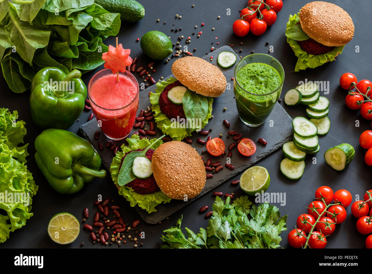 Gesund Vegan essen. Frisches Gemüse auf schwarzem Hintergrund. Detox Diät. Verschiedene bunte frische Säfte. Stockfoto