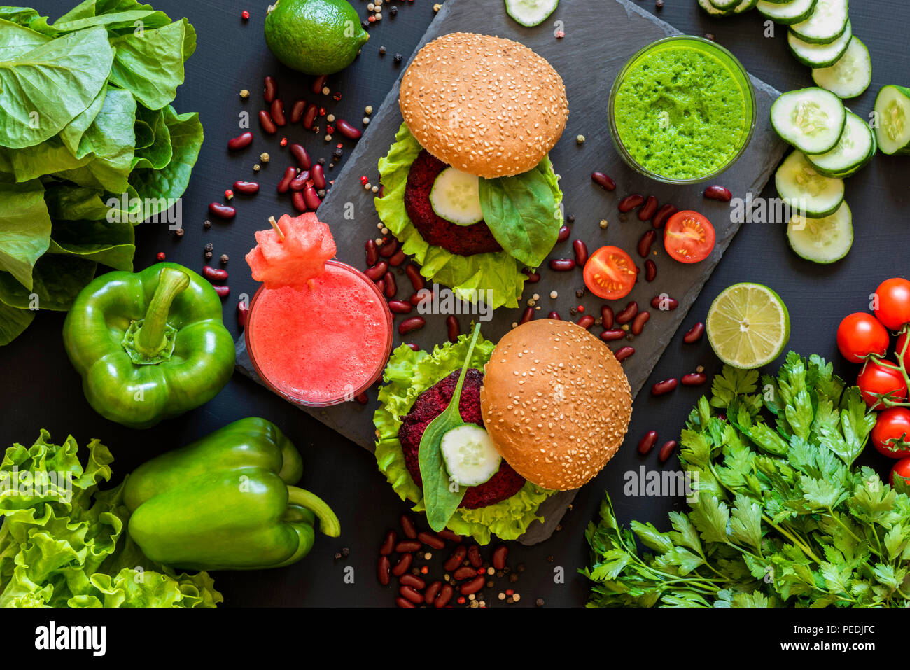 Gesund Vegan essen. Frisches Gemüse auf schwarzem Hintergrund. Detox Diät. Verschiedene bunte frische Säfte. Flach Stockfoto