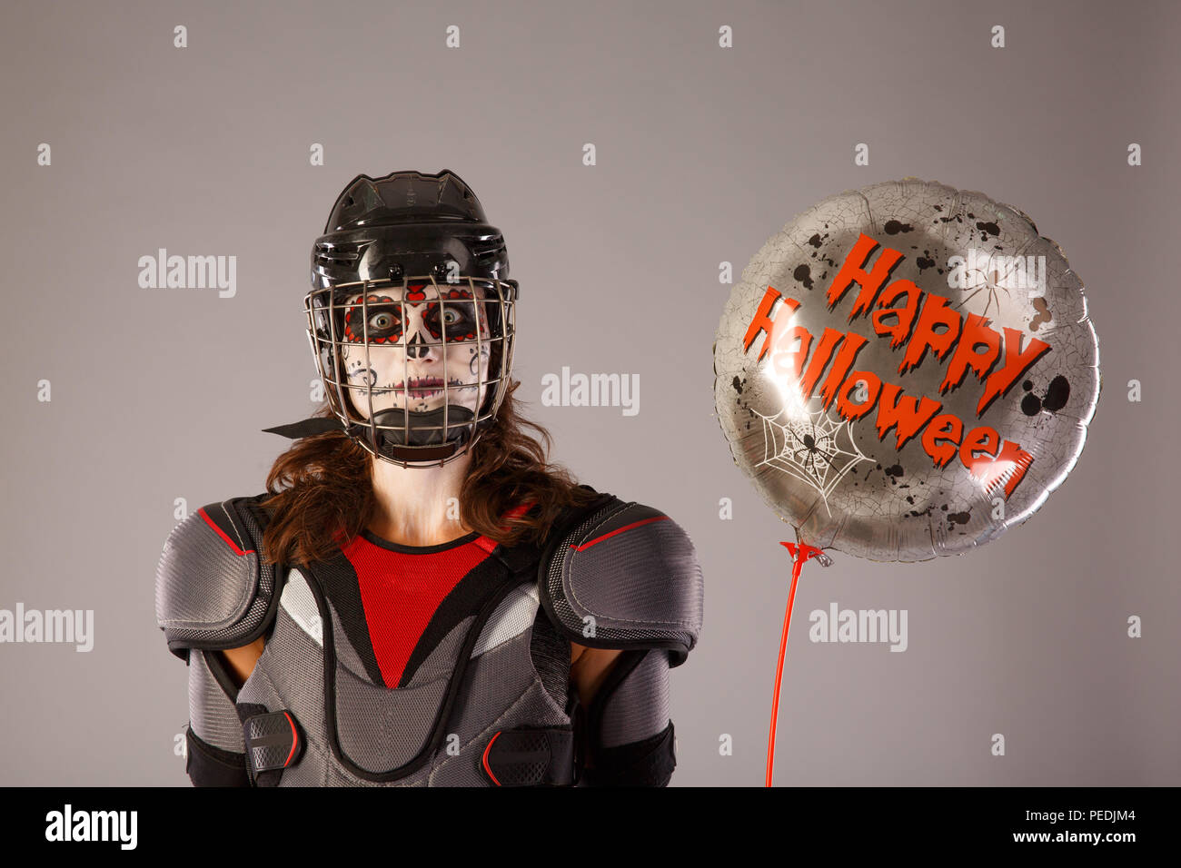 Happy Halloween. hockey player in einem hockey Helm und Maske mit einem Ballon gegen die isolierten Hintergrund. Urlaub Halloween. Allerheiligen Stockfoto