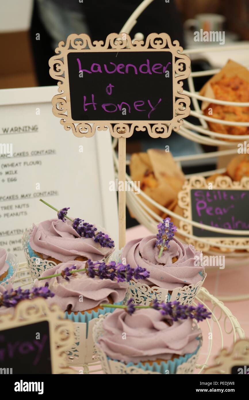 Platte von Lavendel und Honig Cupcakes mit Zuckerglasur und Lavendel mit Creme Hand schriftliche Zeichen in Lila mit einem Food Festival Stockfoto