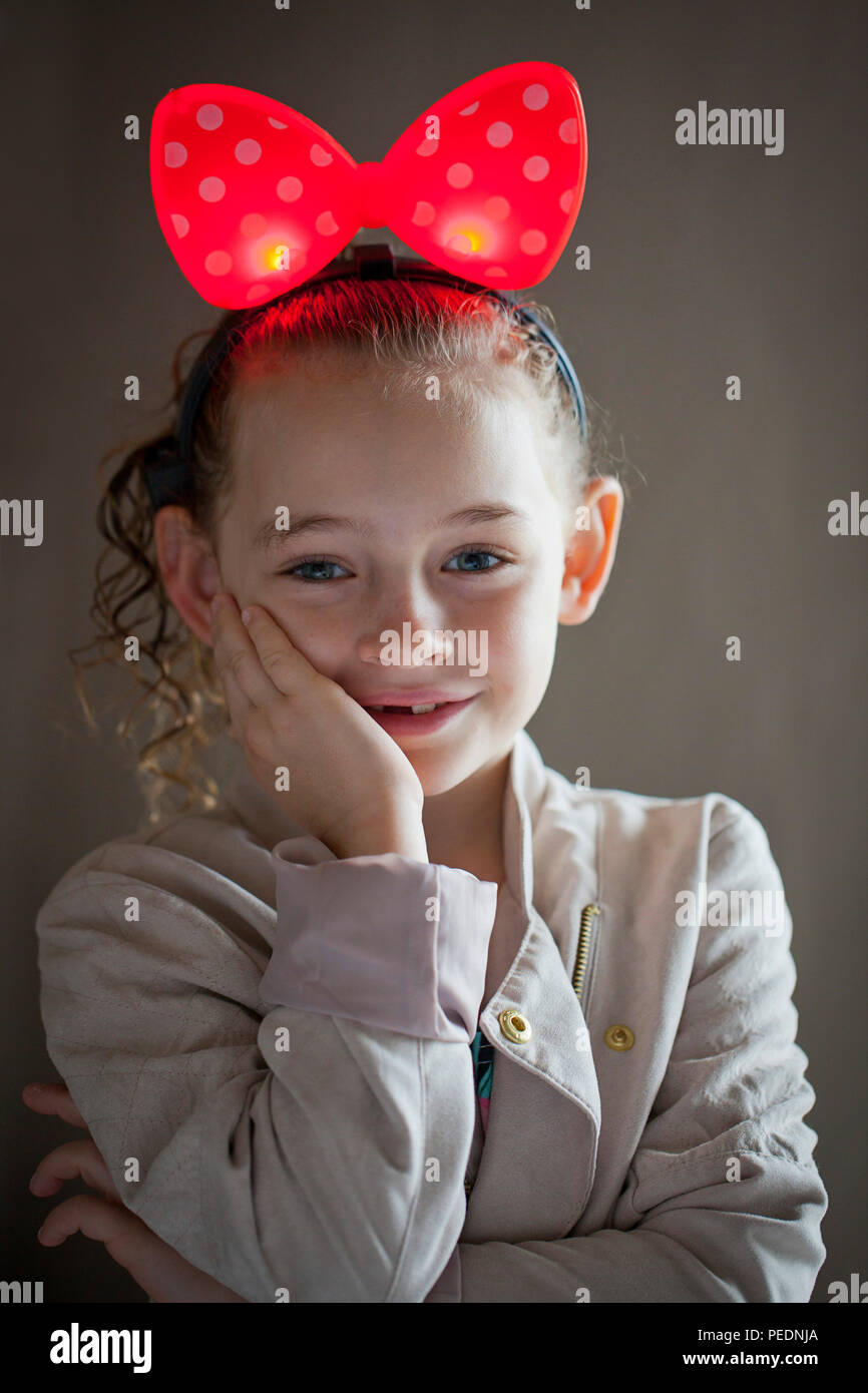 Hübsches kleines Mädchen mit großen roten Tupfen Bug Stockfoto