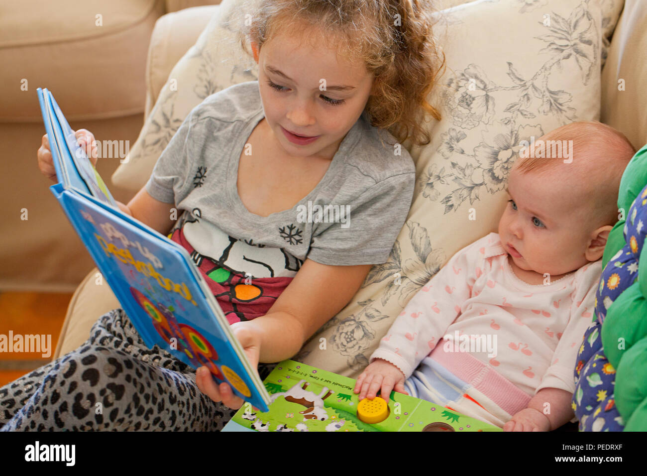 Junge Mädchen das Lesen zu einem Baby girl Stockfoto