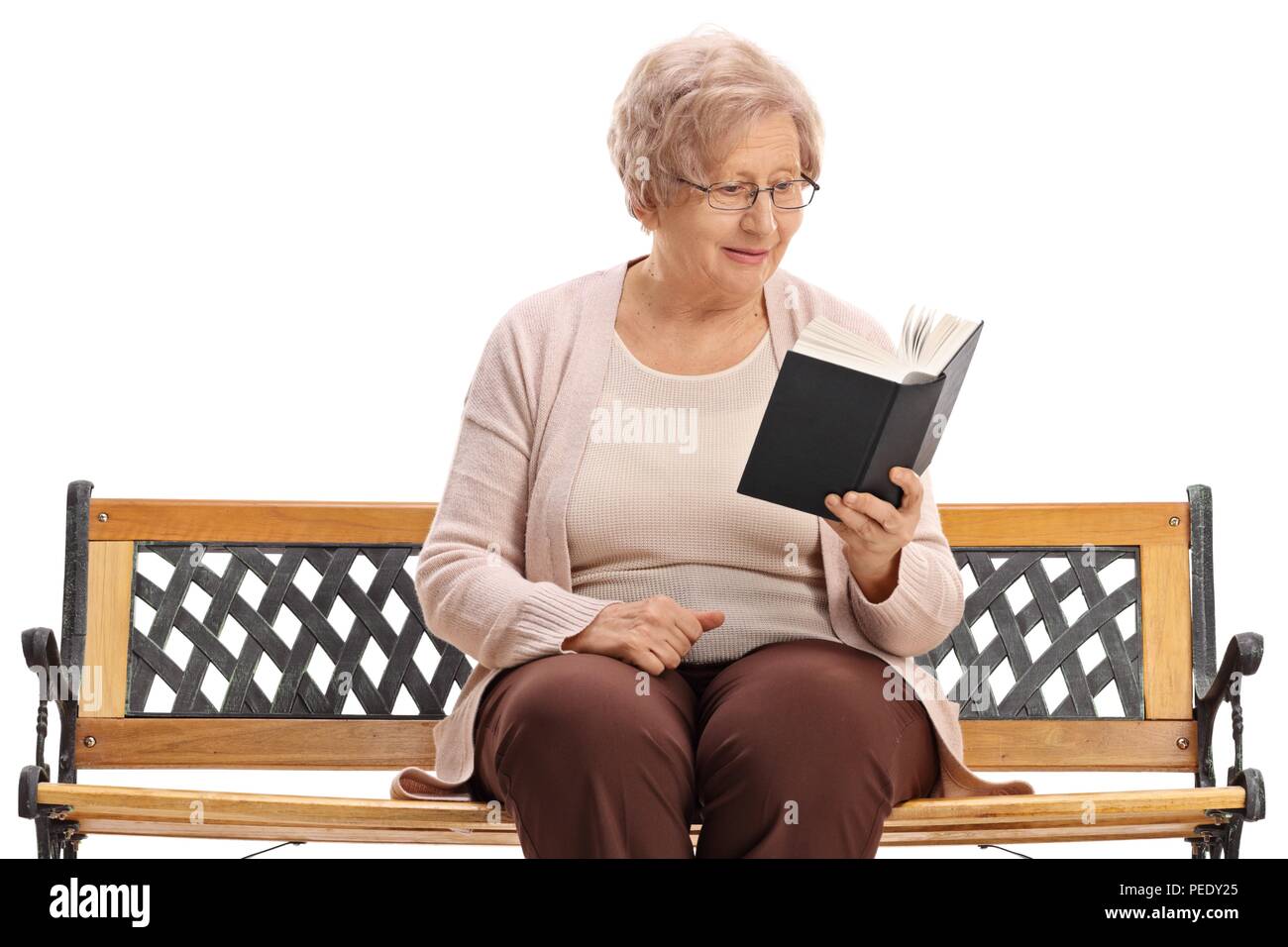 Ältere Frau auf einer Bank sitzen und ein Buch lesen auf weißem Hintergrund Stockfoto