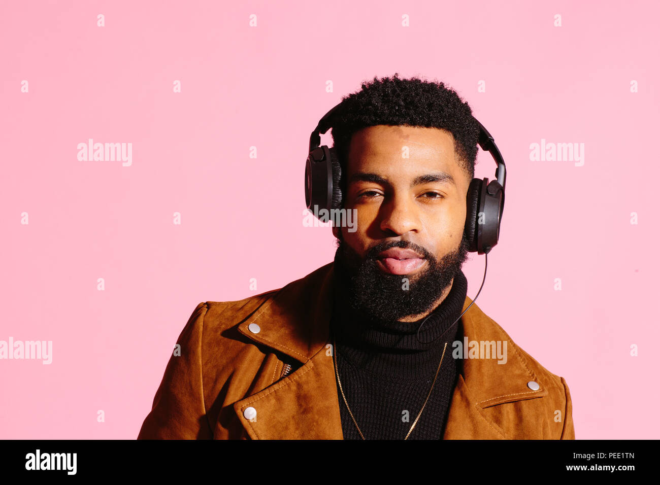 Cool afrikanische amerikanische Mann mit Bart und Kopfhörern. Auf Pink  Studio Hintergrund isoliert Stockfotografie - Alamy