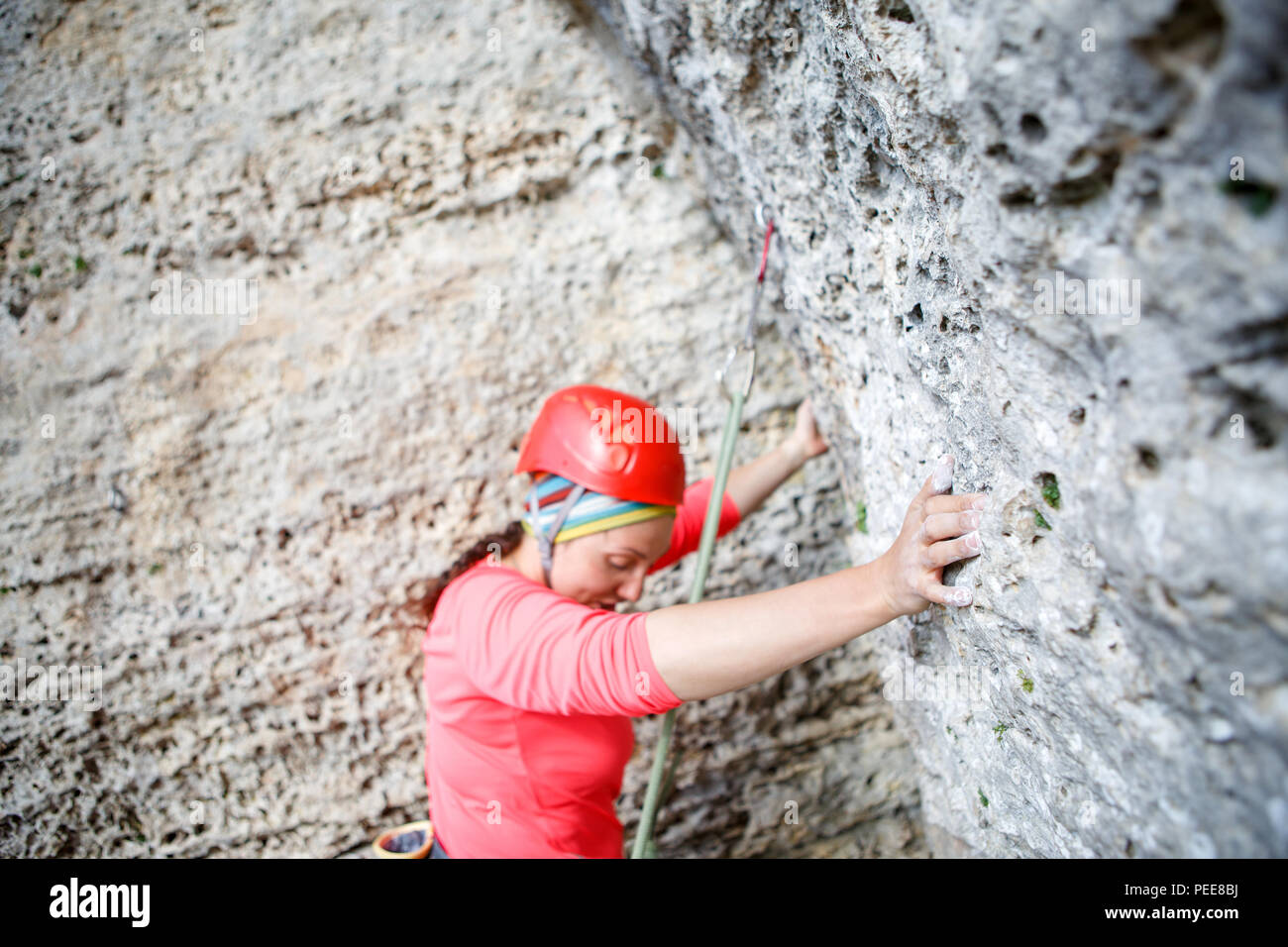 Foto von der Rückseite der Frau im Rosa t-shirt mit Seilsicherung auf dem Hintergrund der Berg Stockfoto