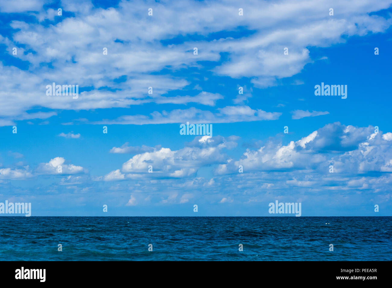 Meer Landschaft ist ein Kiesstrand mit Wellen in weißer Schaum, einem schönen Himmel mit Wolken, ein warmer Sommertag Stockfoto