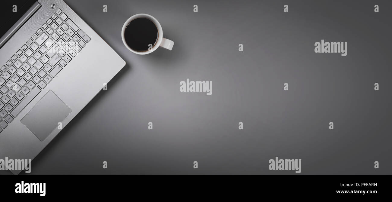 Laptop und Kaffee Tasse auf grauem Hintergrund mit Kopie Raum. top View Stockfoto