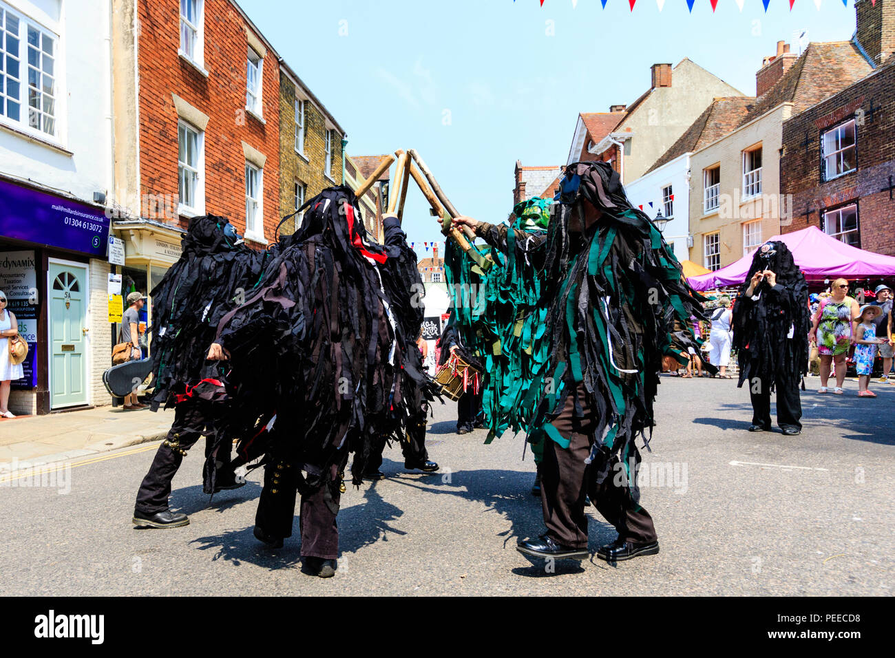 Traditionelle englische Volkstänzer, die Wilde Jagd Morris Dance Seite, in Schwarz tatter Jacken, Tanzen auf der Straße am Sandwich Folk und Ale-Festival. Stockfoto