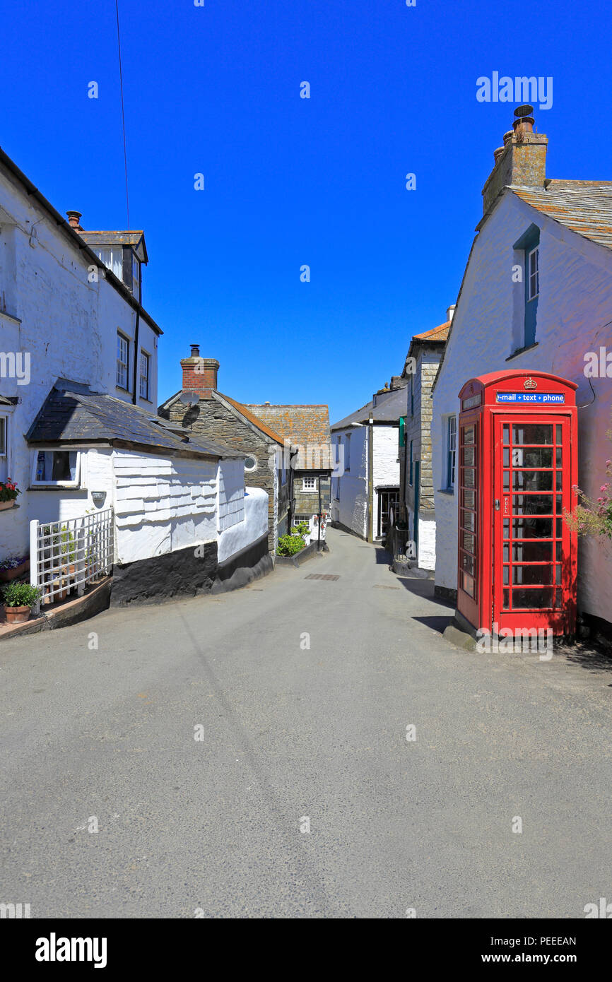 Weiß getünchten Häuschen und ein rotes Telefon Kiosk auf einer schmalen Straße in Port Isaac, Lage der ITV-Serie Doc Martin, Cornwall, England, Großbritannien. Stockfoto