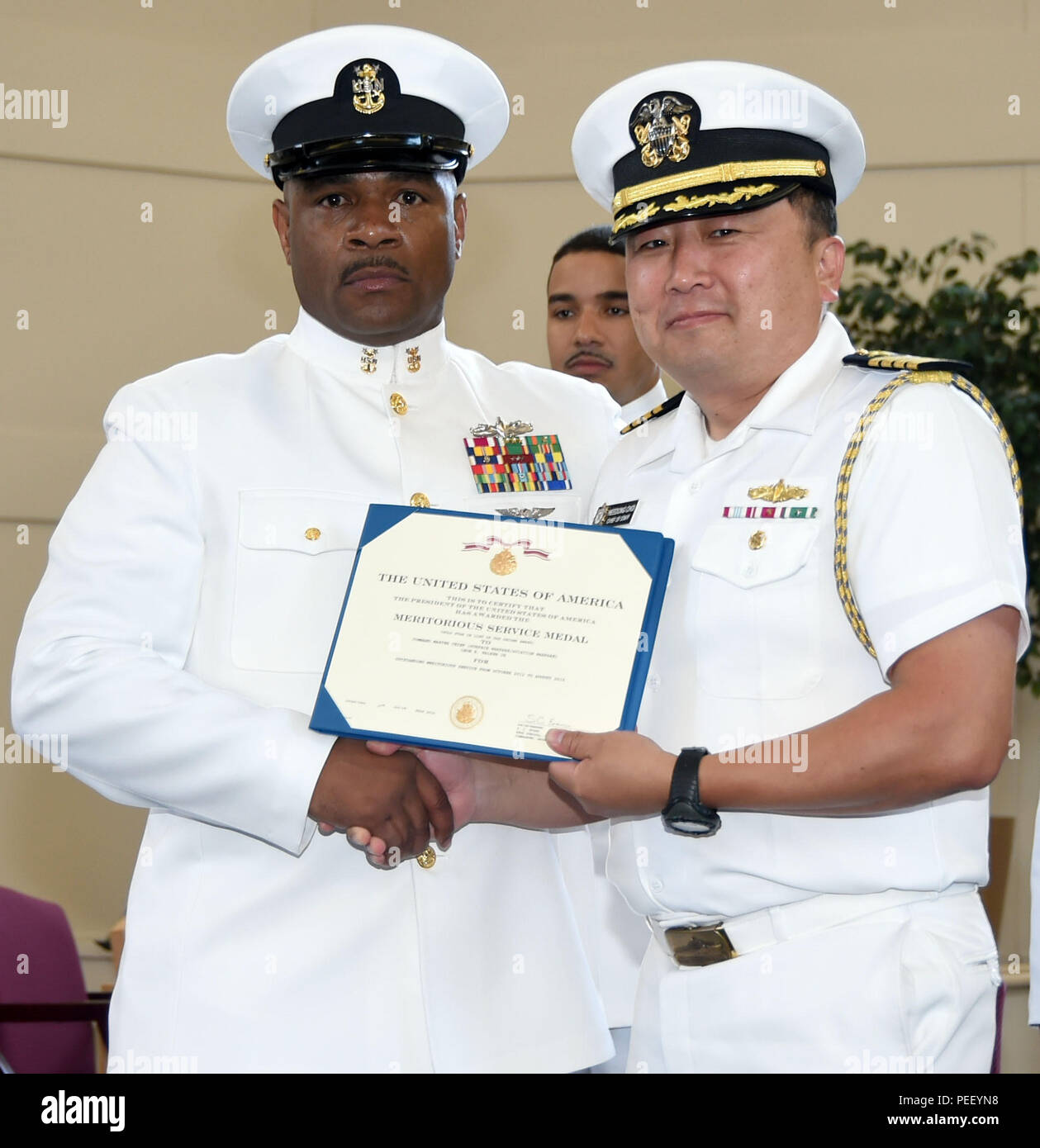 GREAT LAKES, Illinois, (August 7, 2015) - Naval Service Training Command (NSTC) Stabschef Kapitän Heedong Choi (rechts) präsentiert eine Meritorious Service Medal zu Command Master Chief Leon R. Walker Jr. während einer Zeremonie für den Ruhestand Walker in der Recruit Training Command (RTC) Memorial Kapelle hier Rekrutieren, Aug. 7. Walker's letzte Befehl wurde als der Befehl Master Chief für Nstc und er zieht sich nach 32 Jahren im Dienst der United States Navy. (Offizielle U.S. Navy Foto von Scott A. Thornbloom) Stockfoto