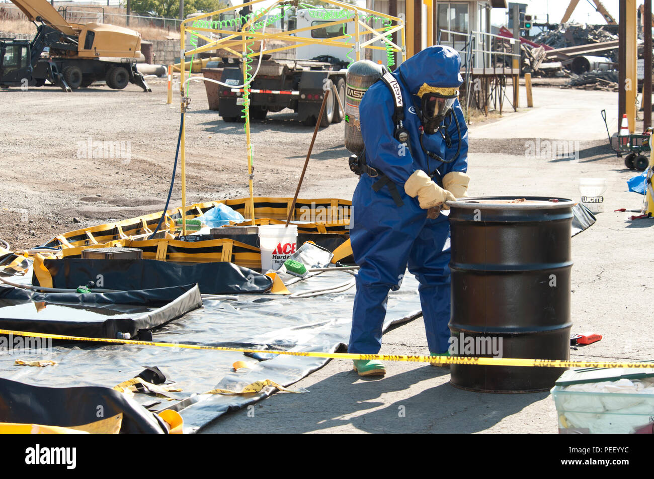 Senior Airman Nicholas Bouselli, 92. Bauingenieur Squadron Emergency Management Facharbeiter, nähert sich einem Metall mit der Kleidung, der direkt zu einem chlorgas Leck ausgesetzt 12.08.2015 Trommel, bei Pacific Stahl- und Recycling in Spokane, Washington mehr als 25 Personen von den Auswirkungen der chemischen Leck und haben sich seitdem durch medizinische Ersthelfer behandelt worden. (U.S. Air Force Foto/Flieger Sean Campbell) Stockfoto
