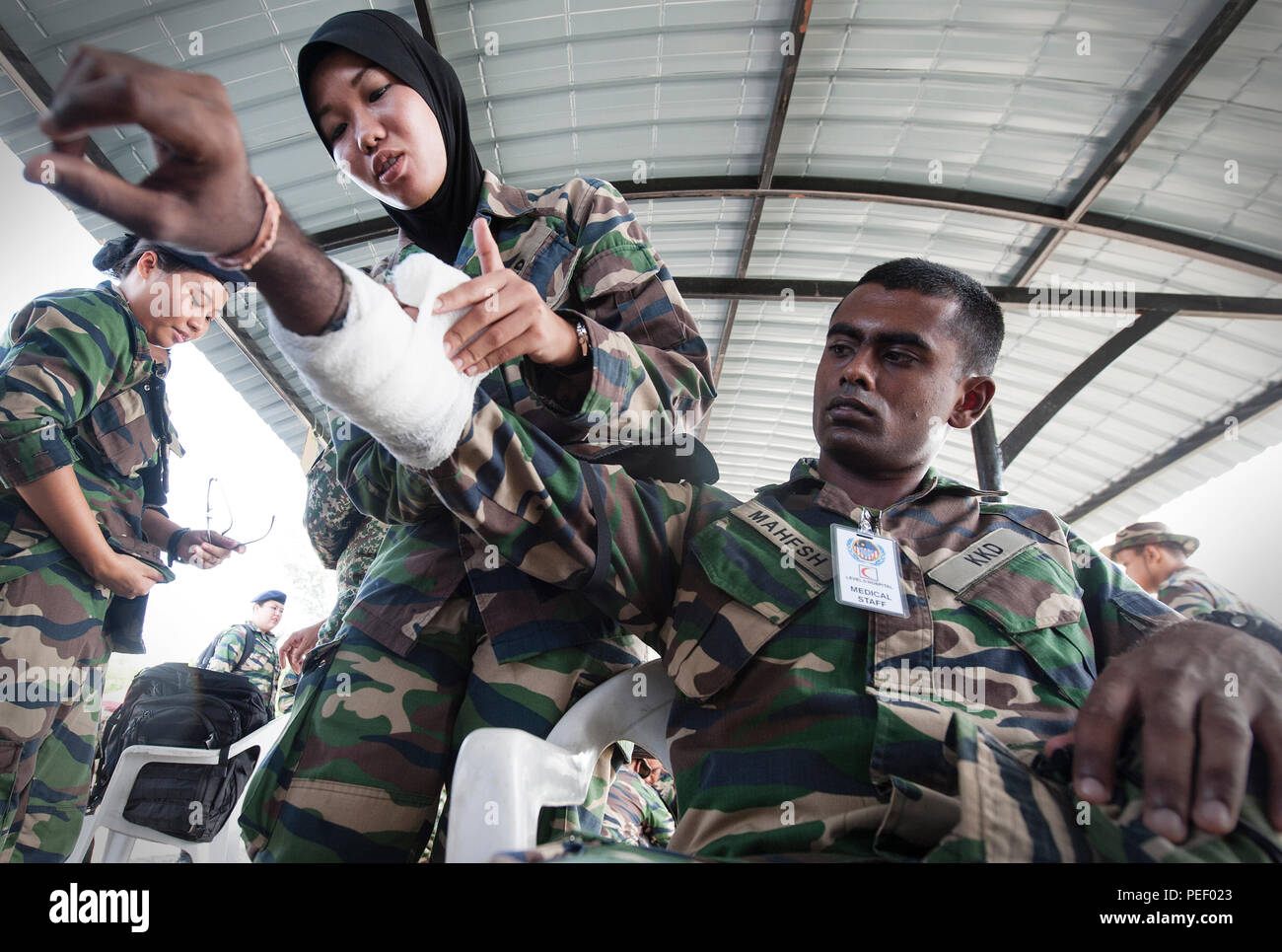 Der malaysischen Armee Cpl. Natasya Nazar, 2. medizinische Einheit Sanitäter, wendet einen Verband zu einem simulierten Unfall während des First Responder medizinische Ausbildung mit der Oklahoma Army National Guard als Teil der Übung Keris Aman 2015 Segenting Camp, 12.08.12, in Port Dickson, Malaysia. Keris Aman ist das größte Multinationale Ausbildung Veranstaltung in diesem Jahr und wird gemeinsam von der Malaysischen Streitkräften und US Pacific Command mit Vertretern aus 29 Nationen hosted teilnehmen. Die Ziele der Veranstaltung sind zur Erhöhung der Interoperabilität und der friedenserhaltung Fähigkeiten der Teilnehmer vor dem deployme Stockfoto Der malaysischen Armee Cpl. Natasya Nazar, 2. medizinische Einheit Sanitäter, wendet einen Verband zu einem simulierten Unfall während des First Responder medizinische Ausbildung mit der Oklahoma Army National Guard als Teil der Übung Keris Aman 2015 Segenting Camp, 12.08.12, in Port Dickson, Malaysia. Keris Aman ist das größte Multinationale Ausbildung Veranstaltung in diesem Jahr und wird gemeinsam von der Malaysischen Streitkräften und US Pacific Command mit Vertretern aus 29 Nationen hosted teilnehmen. Die Ziele der Veranstaltung sind zur Erhöhung der Interoperabilität und der friedenserhaltung Fähigkeiten der Teilnehmer vor dem deployme Stockfoto