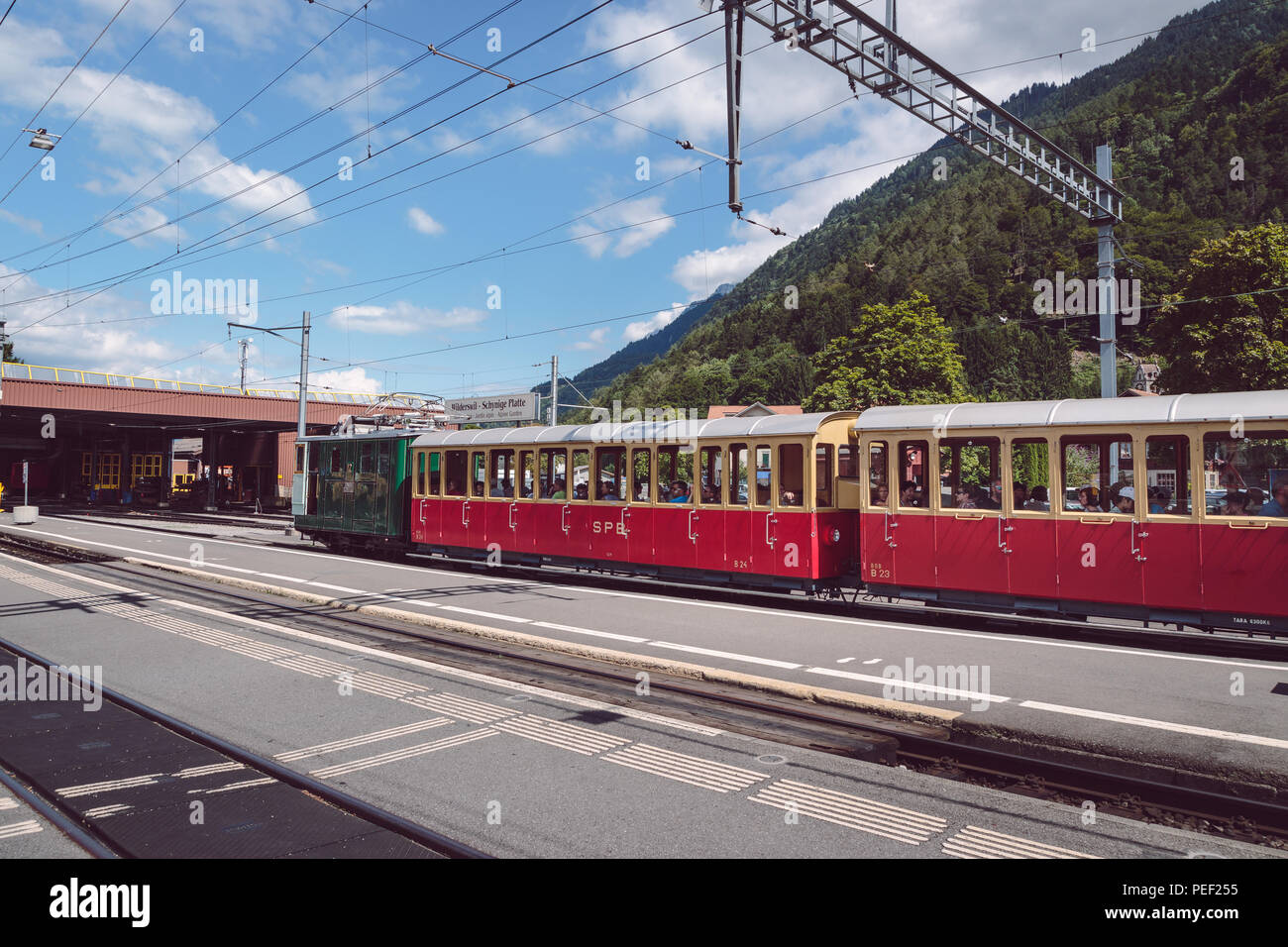 Wilderswil, Berner Oberland, Schweiz - August 5, 2017: retro Passagier Zug kommt in den Bahnhof Wilderswil bei Interlaken von Schy Stockfoto