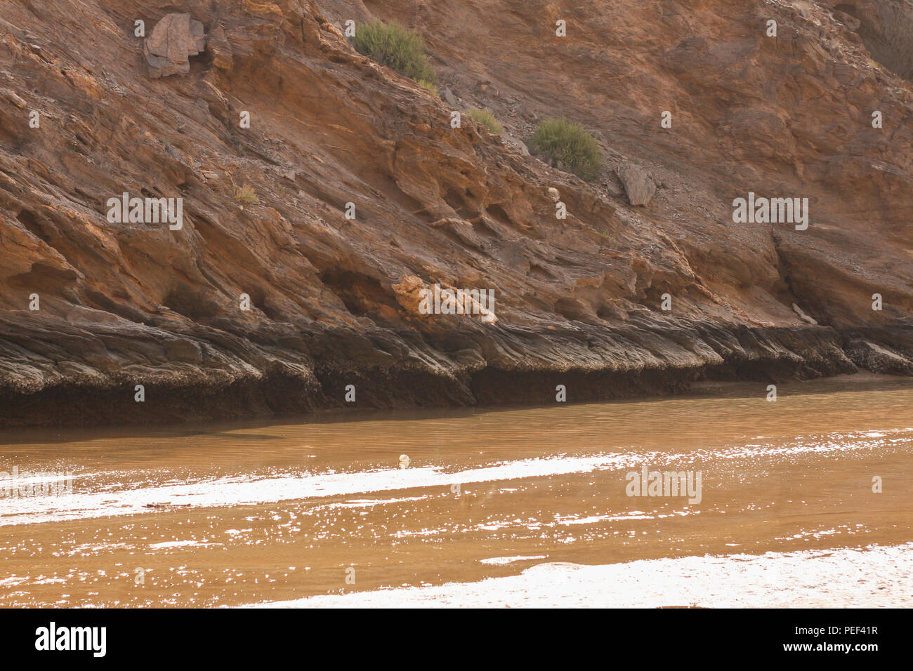 Yiti Muscat Oman Strand an einem sonnigen Tag mit dem trüben Wetter in Bergen im Hintergrund Stockfoto