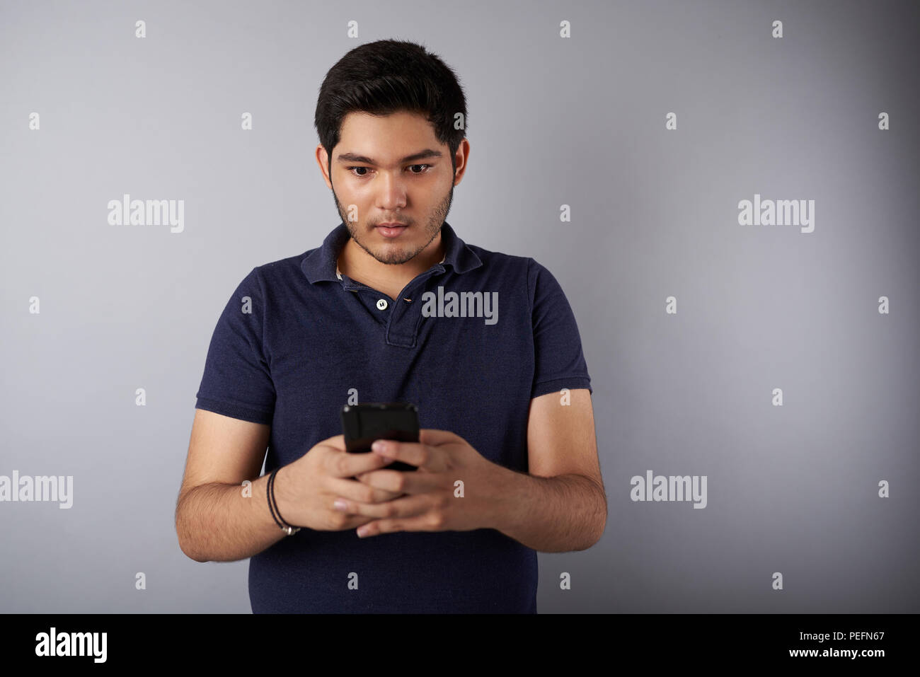 Junge Menschen suchen in Smartphone mit Vernarbtem Gesicht Ausdruck Stockfoto