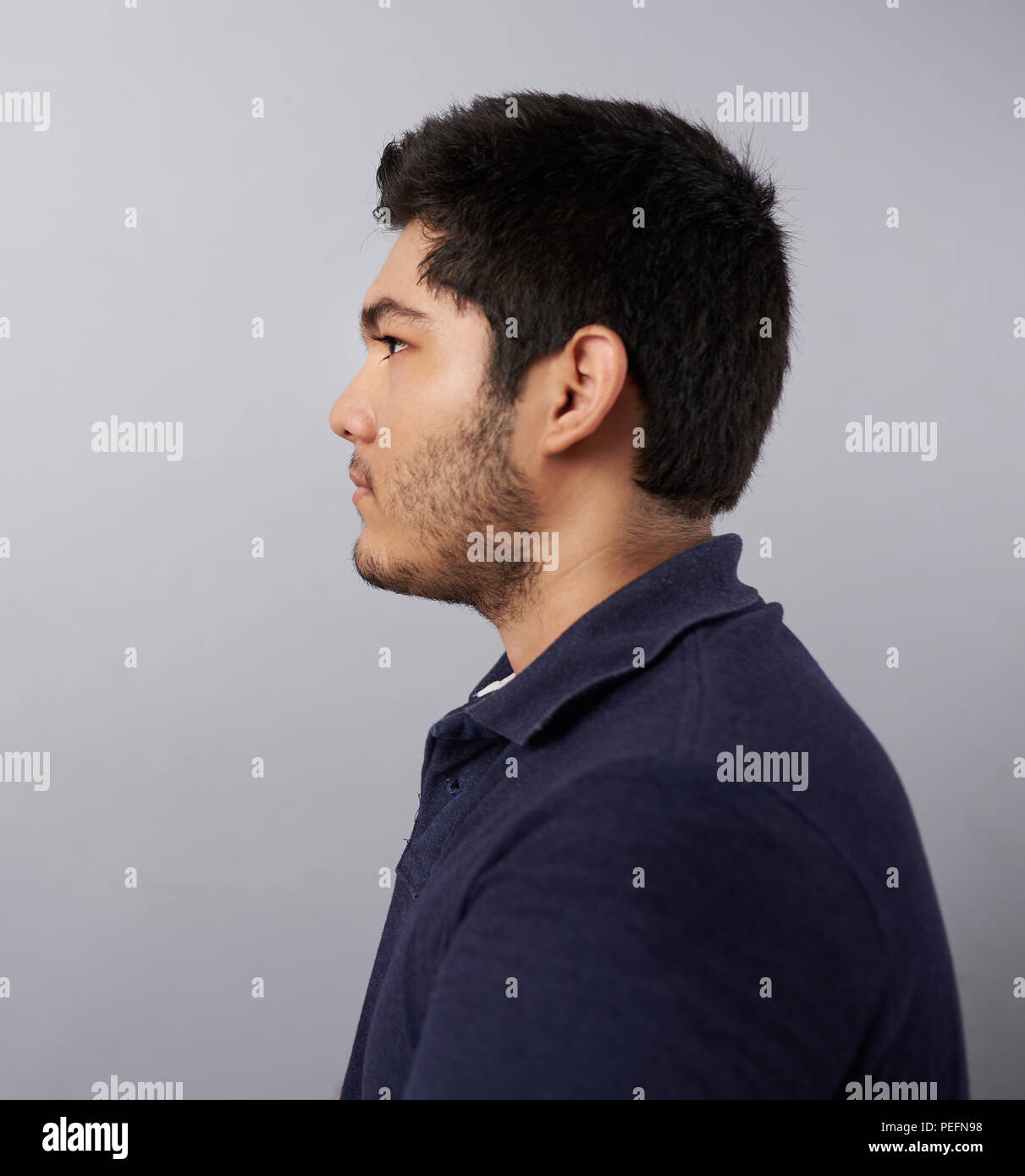 Junger Mann Profil anzeigen auf Grau studio Hintergrund isoliert Stockfoto
