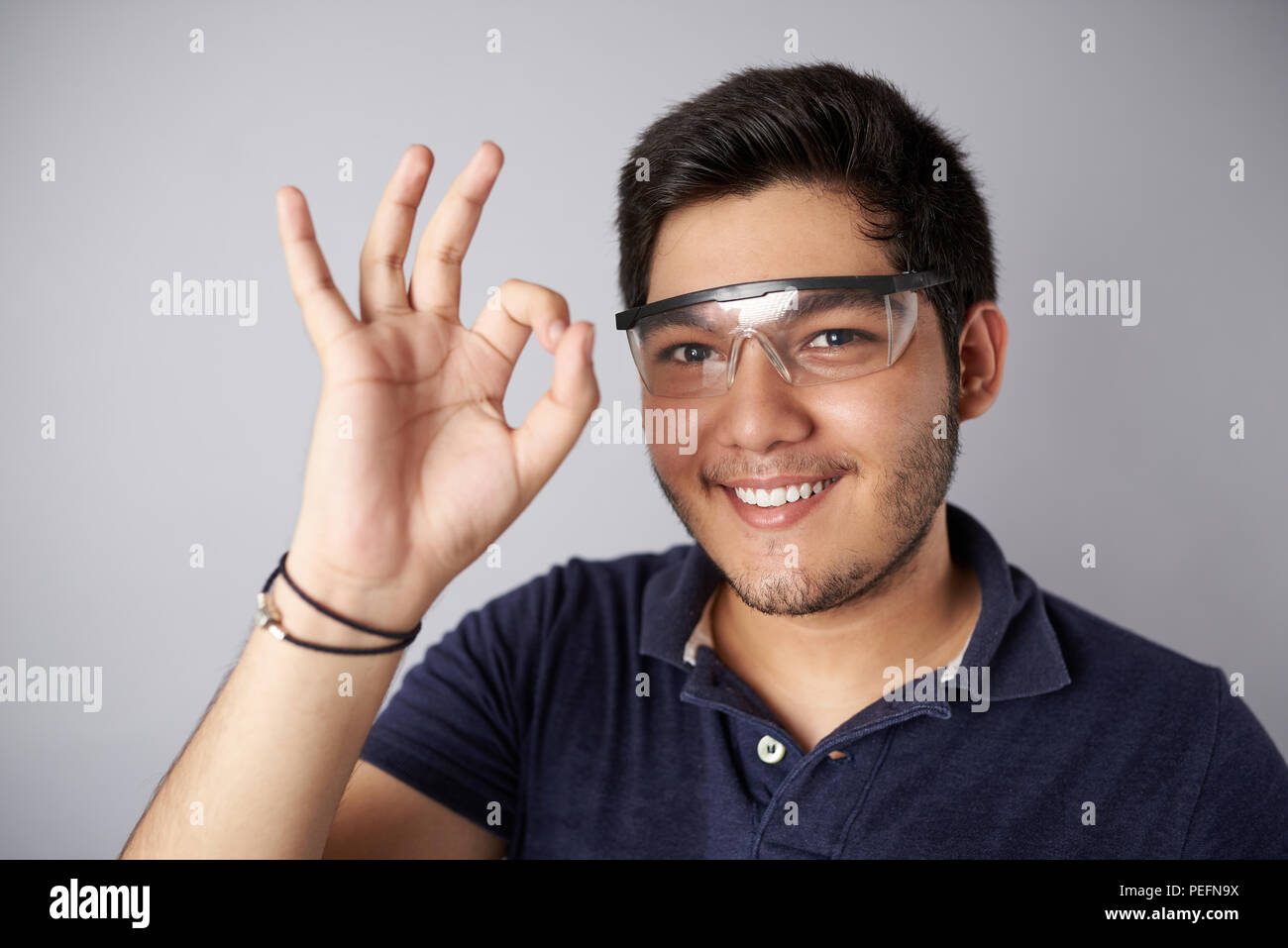 Portrait des jungen Mannes, das Tragen von Schutzbrille, Geste ok Stockfoto