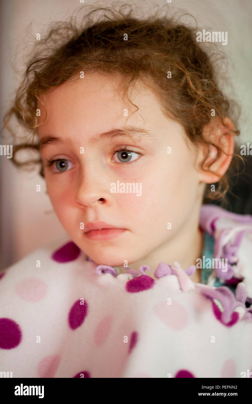 Porträt einer lockigen Haaren 6 jährigen Mädchen tief in Gedanken Stockfoto