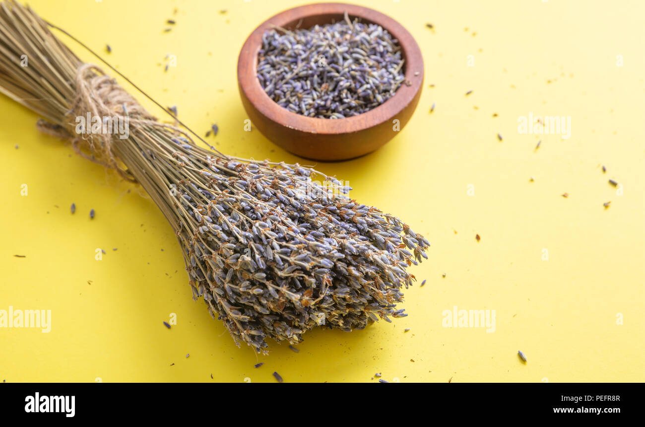 Kräuter Konzept. Ansicht von oben von getrocknetem Lavendel Strauß auf Gelb Tischplatte Hintergrund und in Houten. Stockfoto