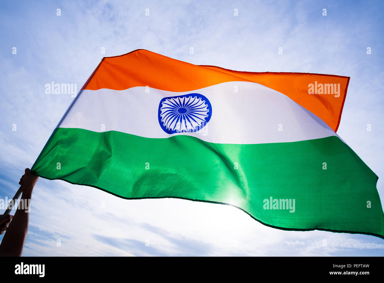 Nahaufnahme, Mann, Hand, die Indien Flagge auf dem Hintergrund des blauen Himmels. Der indischen Unabhängigkeit Tag, den 15. August. Stockfoto