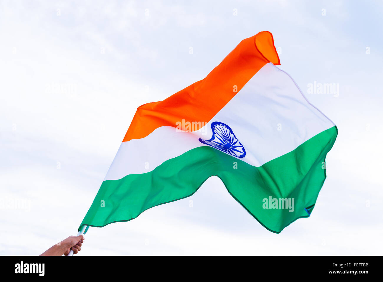 Nahaufnahme, Mann, Hand, die Indien Flagge auf dem Hintergrund des blauen Himmels. Der indischen Unabhängigkeit Tag, den 15. August. Stockfoto