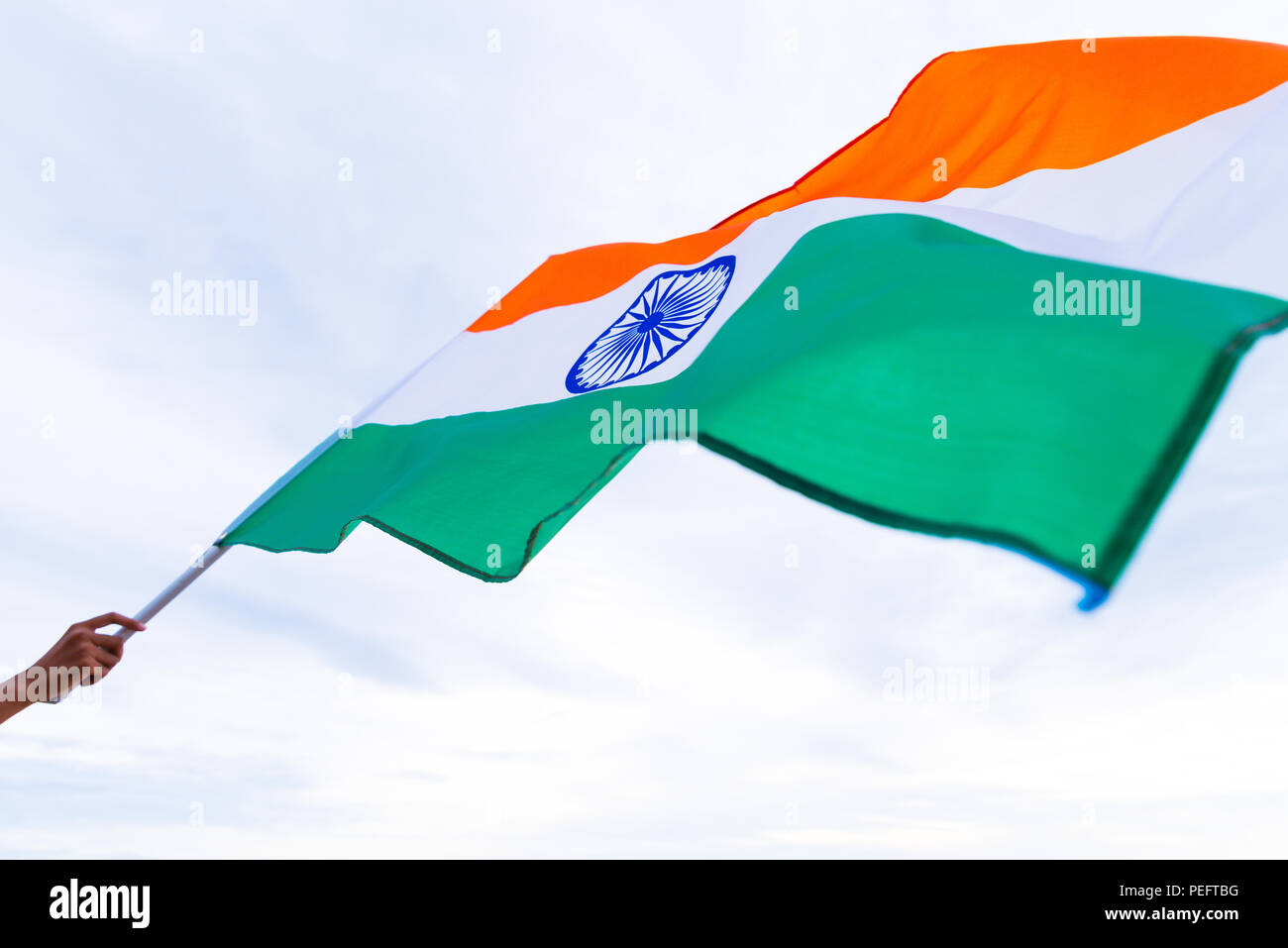 Nahaufnahme, Mann, Hand, die Indien Flagge auf dem Hintergrund des blauen Himmels. Der indischen Unabhängigkeit Tag, den 15. August. Stockfoto