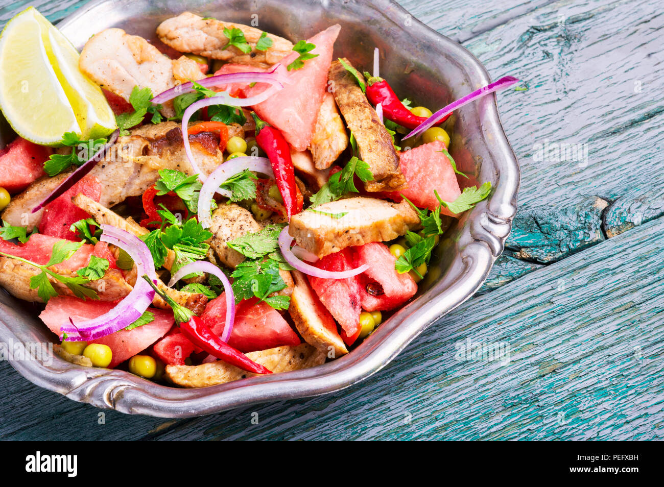 Sommersalat mit Rindersteak, Wassermelone und Gewürzen. Exotische Lebensmittel, Stockfoto
