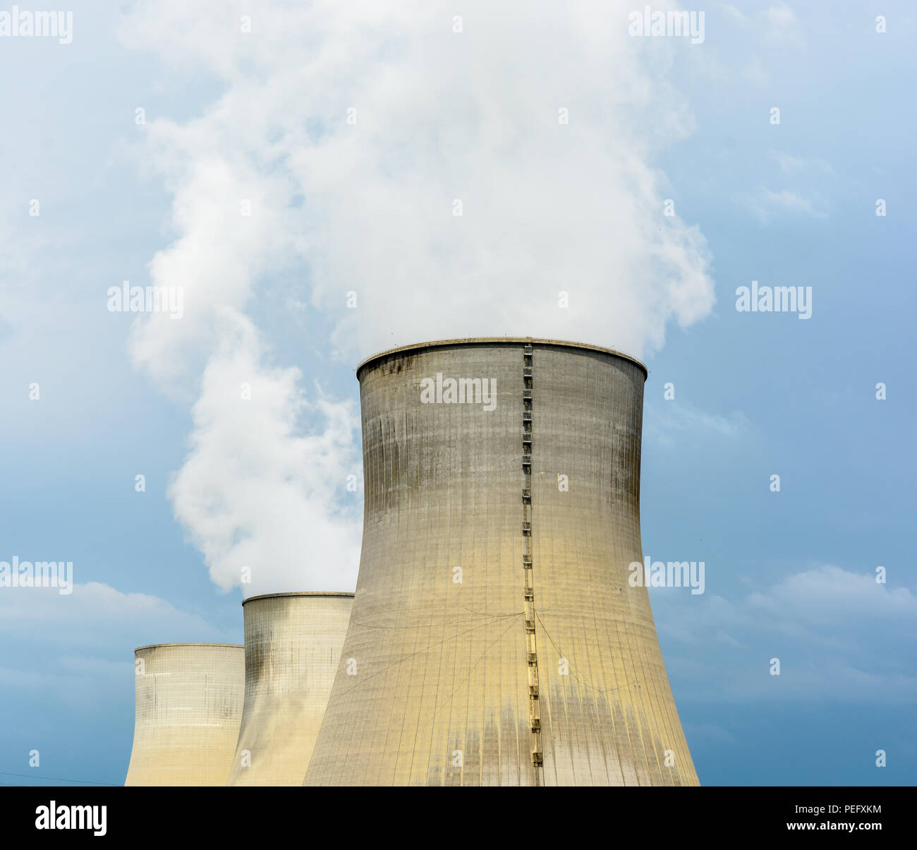Drei natürlichen Entwurf Kühltürme eines Kernkraftwerks loslassen Wolken aus Wasserdampf gegen einen dunklen stürmischen Himmel. Stockfoto