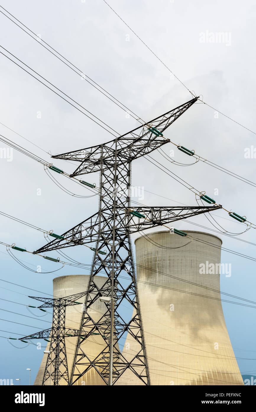 Low Angle View ein Sendemast, der eine hohe Spannung Freileitung mit zwei Kühltürme eines Kernkraftwerks in der backgroun Stockfoto