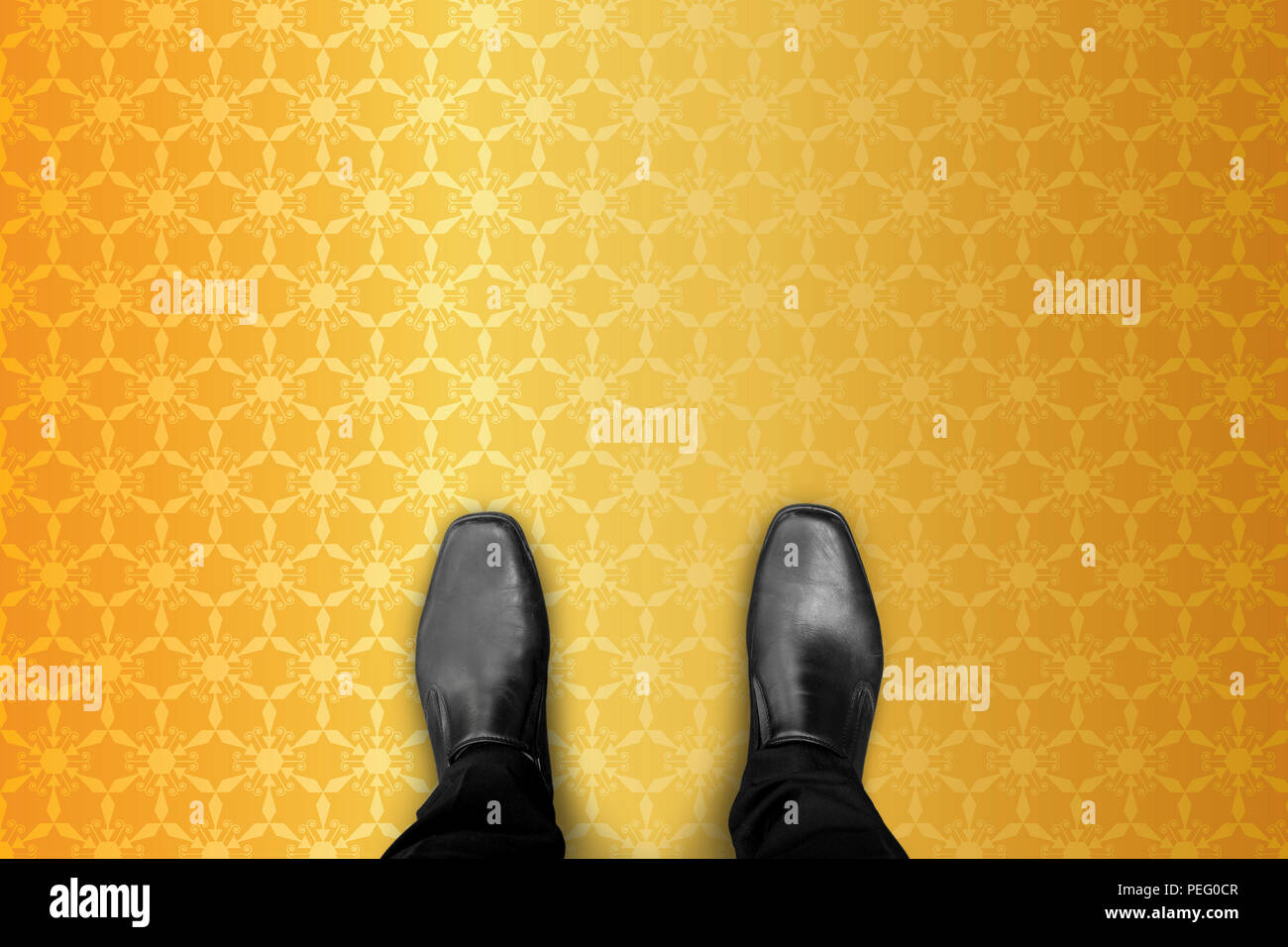 Reichen und Wohlhabenden Millionär Geschäftsmann in schwarze Schuhe stehen auf Gold geometrische Muster. Stockfoto