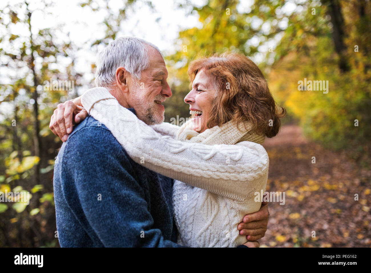 Senior Paar an einander in einem Herbst Natur suchen, umarmen. Stockfoto