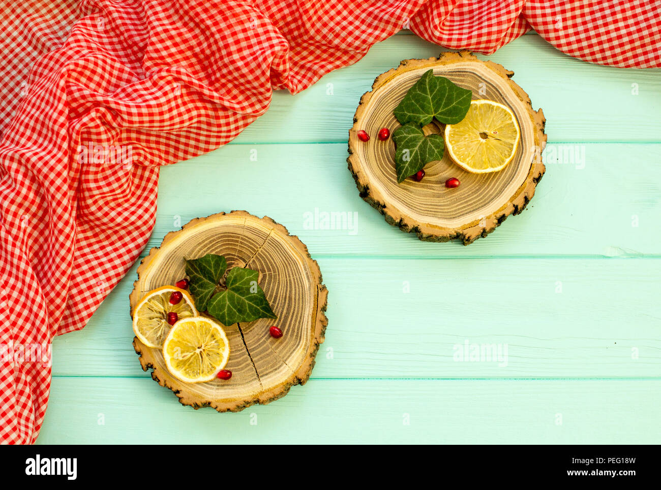 Holz mit mit Zitronenscheiben und Granatapfel Beeren auf einem türkisen Hintergrund Stockfoto