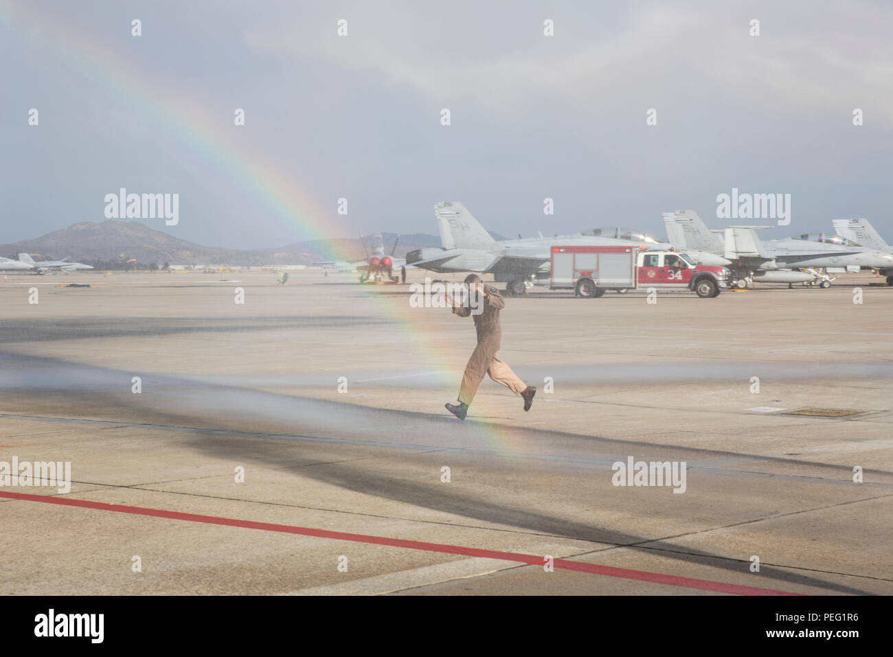 Oberst John farnam, kommandierender Offizier der Marine Corps Air Station Miramar, läuft durch einen künstlichen Dusche nach seinem letzten Flug Durchführung als Kommandierender Offizier an Bord der MCAS Miramar, Kalifornien, 12.08.17. Marines und Familienmitgliedern feierte seinen letzten Flug als MCAS Miramar kommandierender Offizier mit einem traditionellen "wet down." (U.S. Marine Corps Foto von Sgt. Lillian Stephens/Freigegeben) Stockfoto