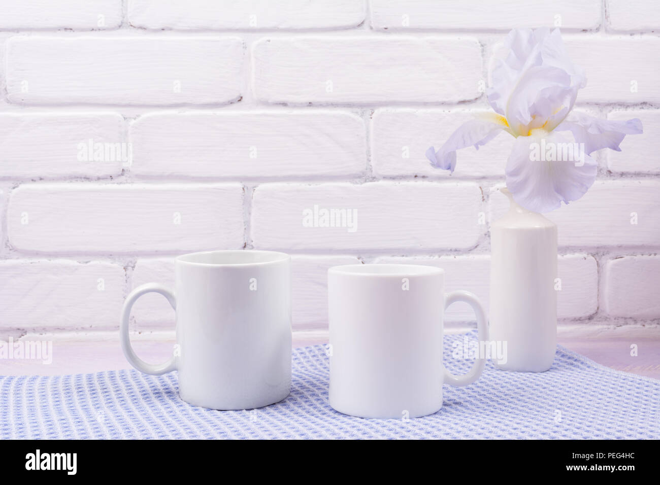 Zwei weiße Kaffeetasse mockup mit blass Lavendel Farbe Iris Blumen. Leere Becher mock up für Design Promotion. Stockfoto