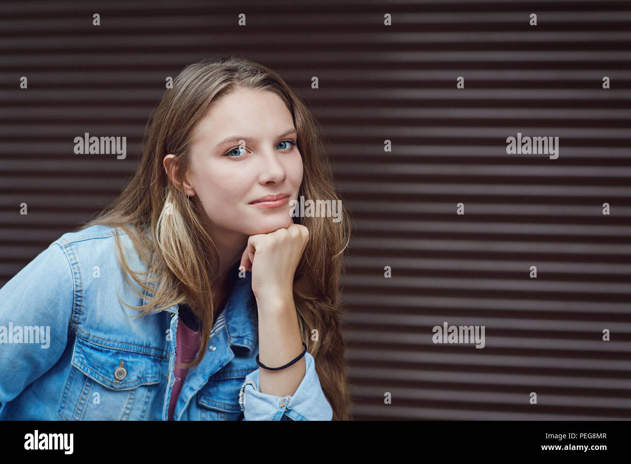 Ein blondes Mädchen in einer ernsten Stimmung auf einer Straße. Stockfoto