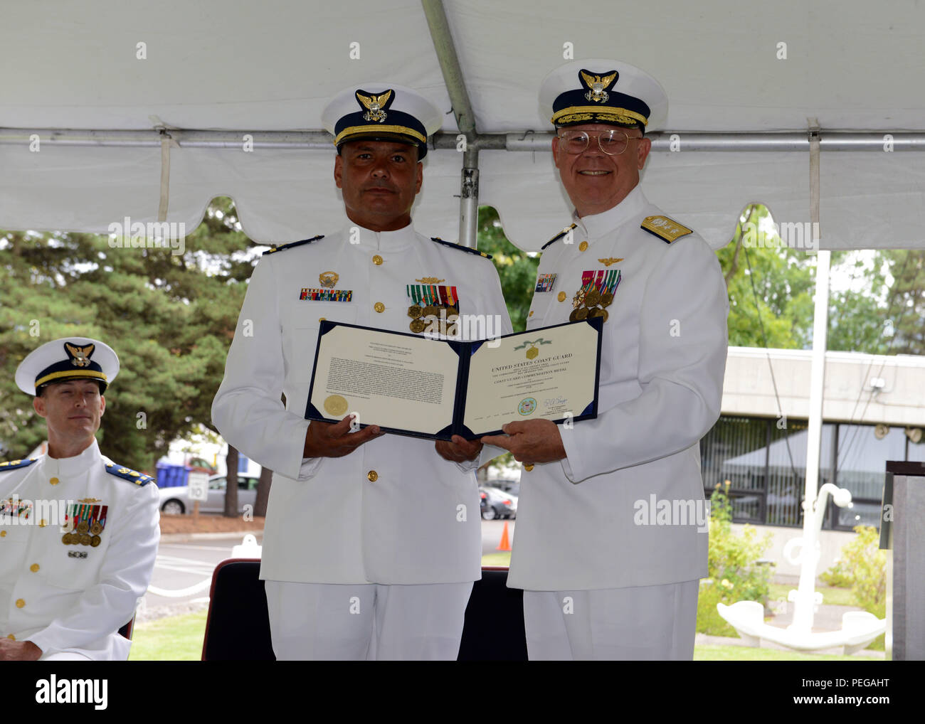 Hintere Adm. Richard Gromlich, Commander, Coast Guard Bezirk 13, präsentiert die Küstenwache Commendation Medal an Chief Warrant Officer Jonathan Placido, kommandierender Offizier, Coast Guard Cutter Bluebell, während eine Änderung der Befehl Zeremonie in Portland, Erz, Aug 14, 2015. Placido hat mehr als 30 Jahre in der Küstenwache serviert. (U.S. Coast Guard Foto von Petty Officer 3rd Class Jonathan Klingenberg) Stockfoto