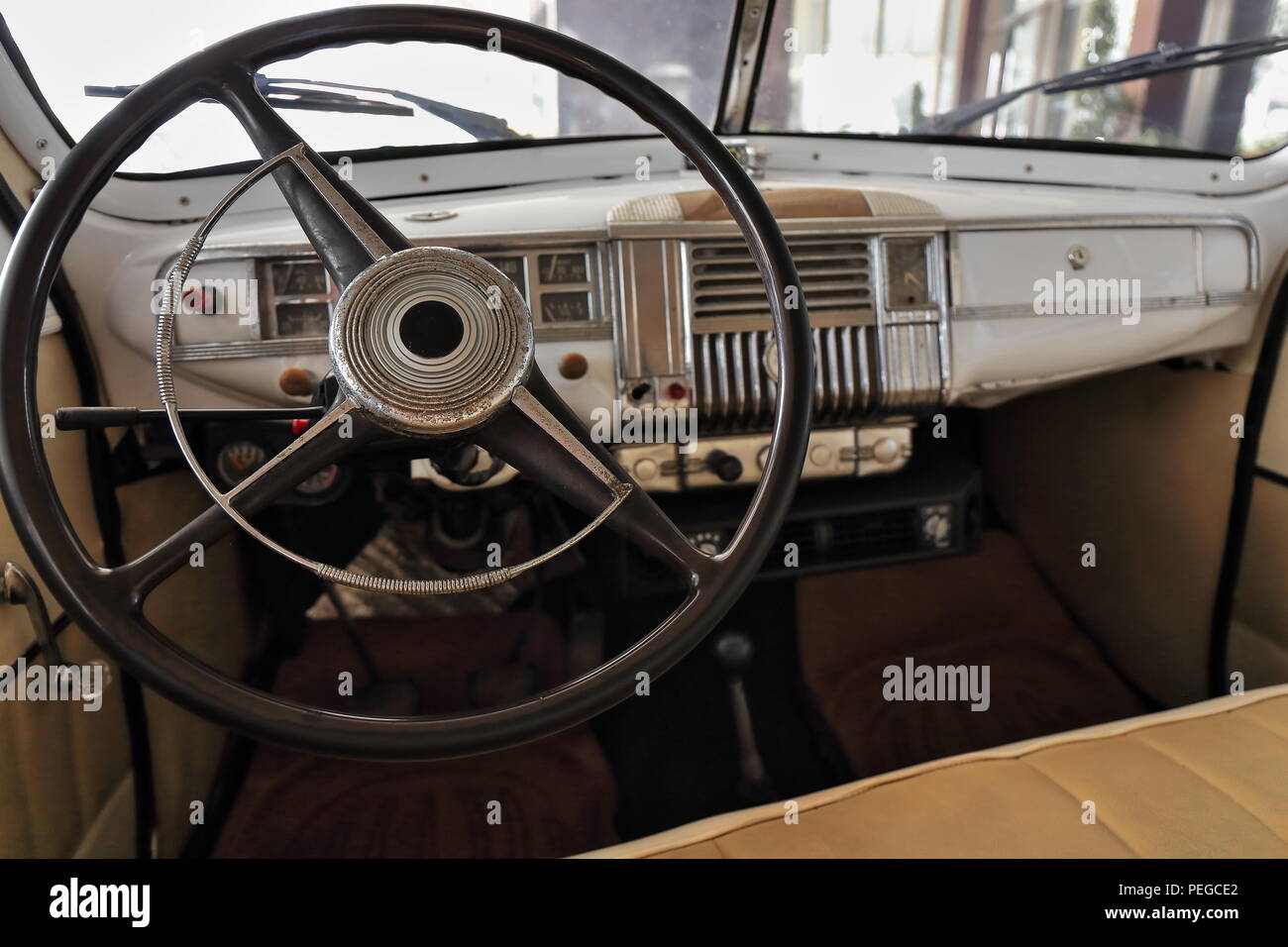 Armaturenbrett Innenansicht - Elfenbein lackierte Karosserie der Oldtimer der 40er Jahre mit drei großen Lenkrad - Halbrunde horn Ring - Doppel Frontscheibe Stockfoto